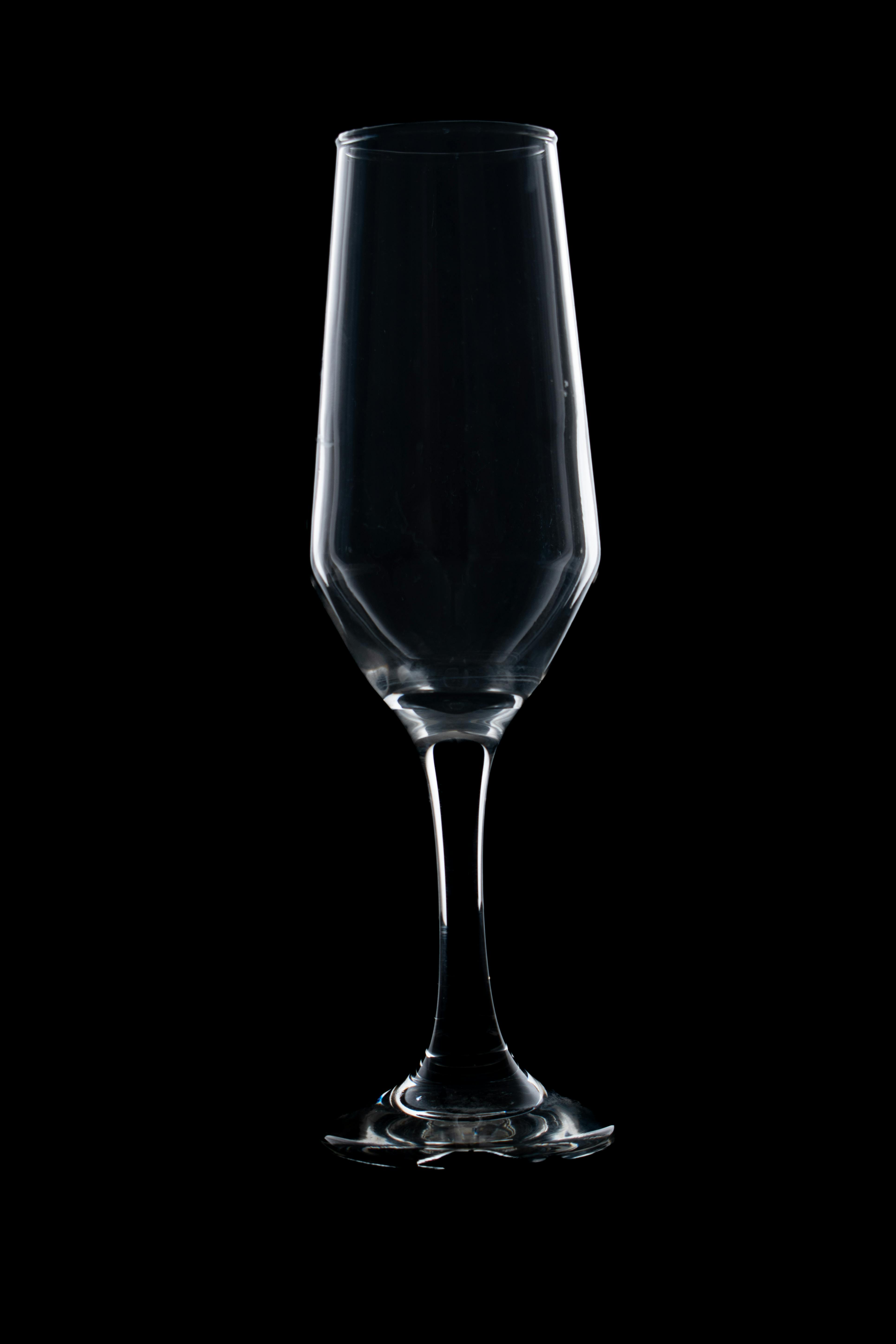 gratis Een minimalistische foto van een leeg champagneglas tegen een zwarte achtergrond, waarbij het elegante ontwerp extra opvalt. Stockfoto