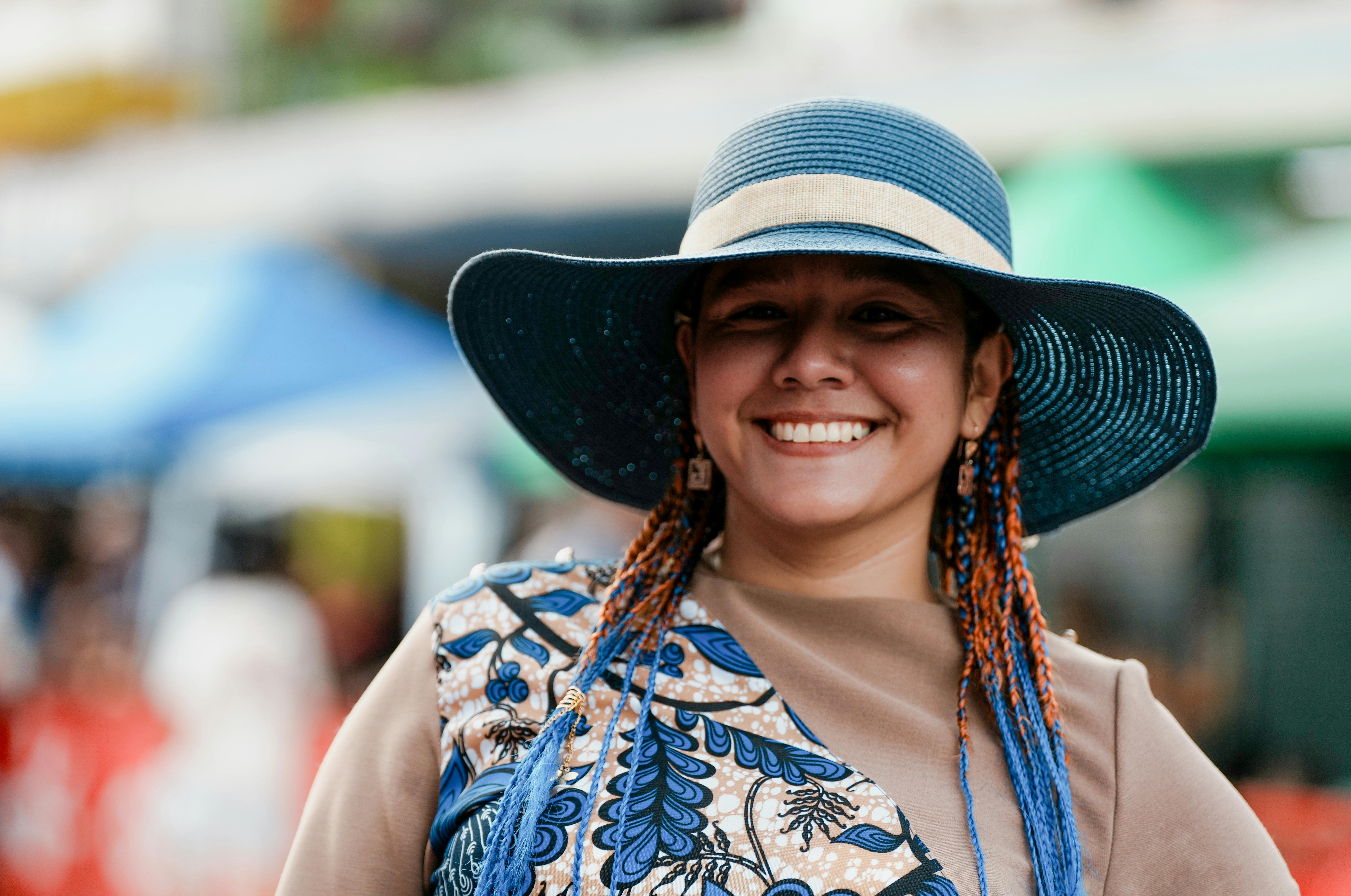 ingyenes Boldog nő színes ruhában és kék kalapban, élvezi a napsütéses napot a piacon Limónban, Costa Ricában. Stockfotó