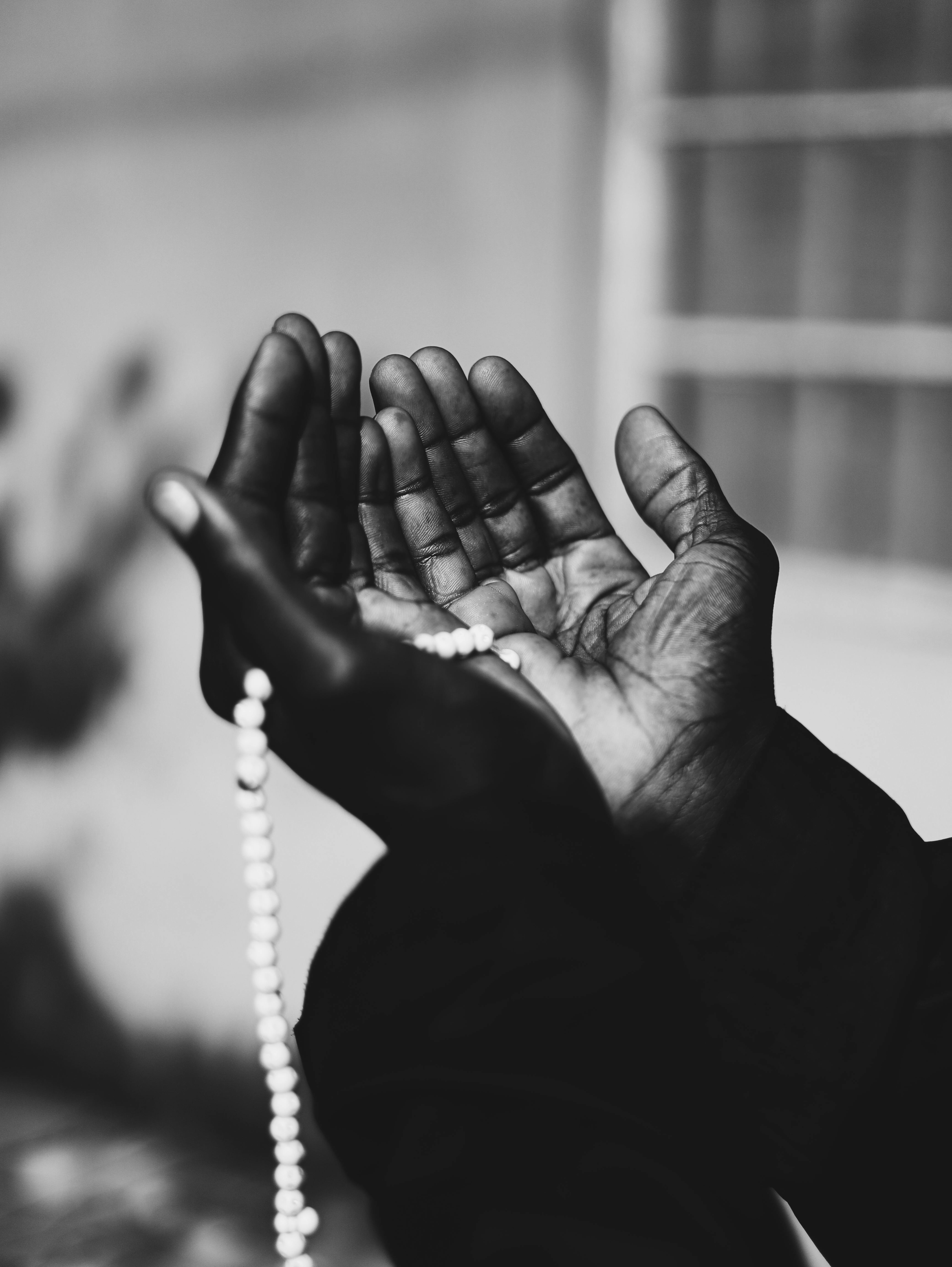 Gratis Sort-hvidt billede af hænder, der holder bedepærer, der symboliserer tro og spiritualitet. Lagerfoto