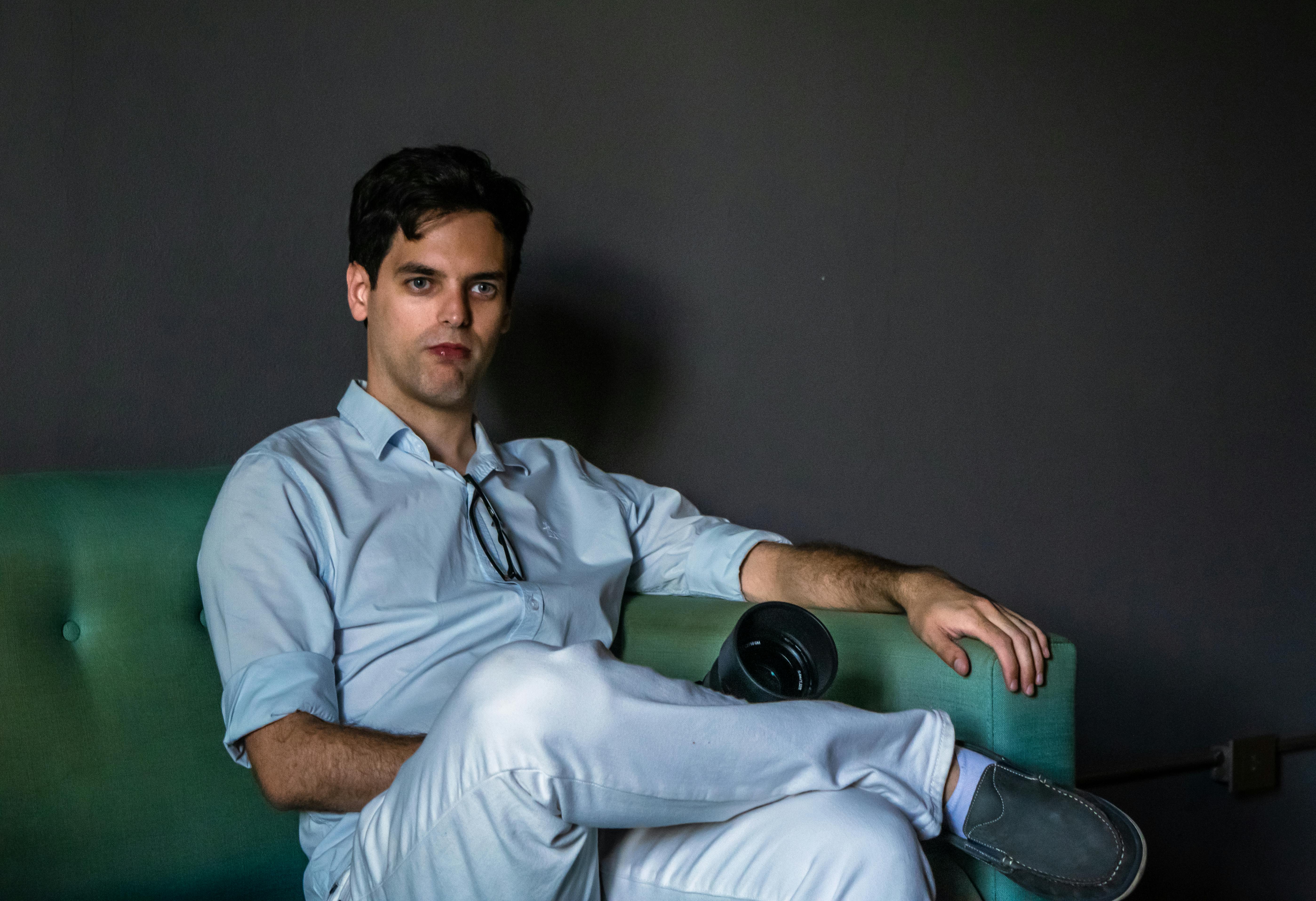 ฟรี ภาพถ่ายแบบสบายๆ ของชายคนหนึ่งในเสื้อเชิ้ตสีฟ้าอ่อน กำลังพักผ่อนบนโซฟาภายในบ้าน คลังภาพถ่าย