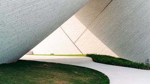 Free Abstract view of modern architecture featuring a geometric walkway and angled walls, creating striking shadows. Stock Photo