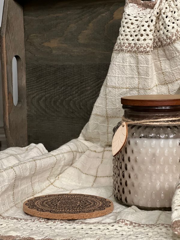 Textured glass candle resting on a cream woven throw — Yelena HeyTam on Pexels