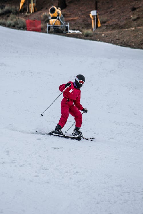 Person in Red Jacket and Red Pants Riding on Snow Ski