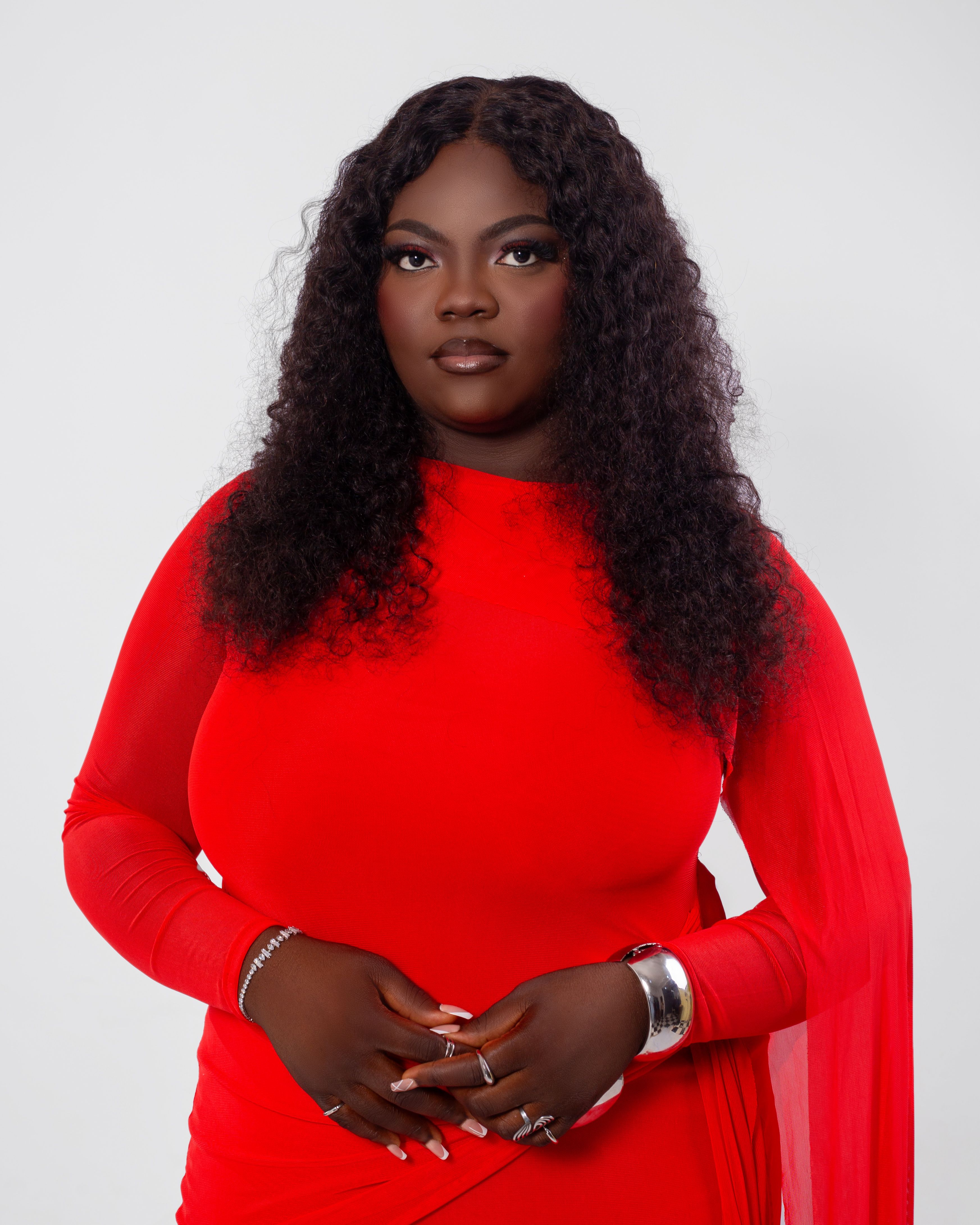 Elegant portrait of a woman in a striking red dress with a neutral background.