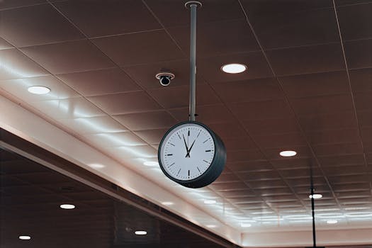 Hanging ceiling clock in a well-lit modern airport interior in Ho Chi Minh City, Vietnam.