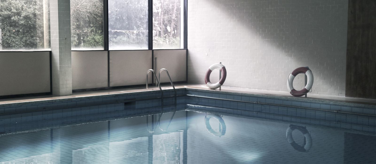 A tranquil indoor swimming pool with life rings and windows in Fiumicino, Italy.