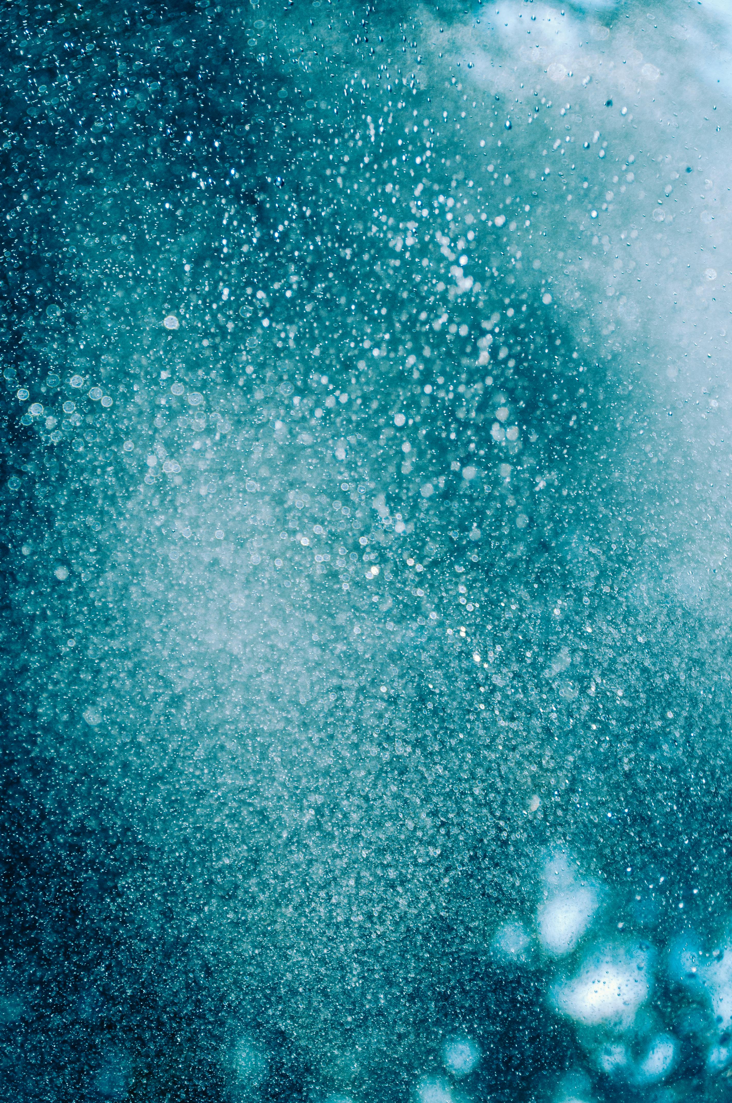 De franc Imatge abstracta dinàmica que captura gotes d'aigua blaves brillants en moviment, creant un teló de fons tranquil i artístic. Foto d'estoc