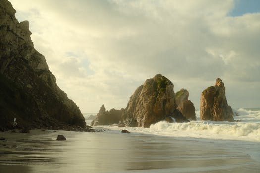Explore the stunning rock formations and serene beaches of Colares, Portugal under a moody sky.