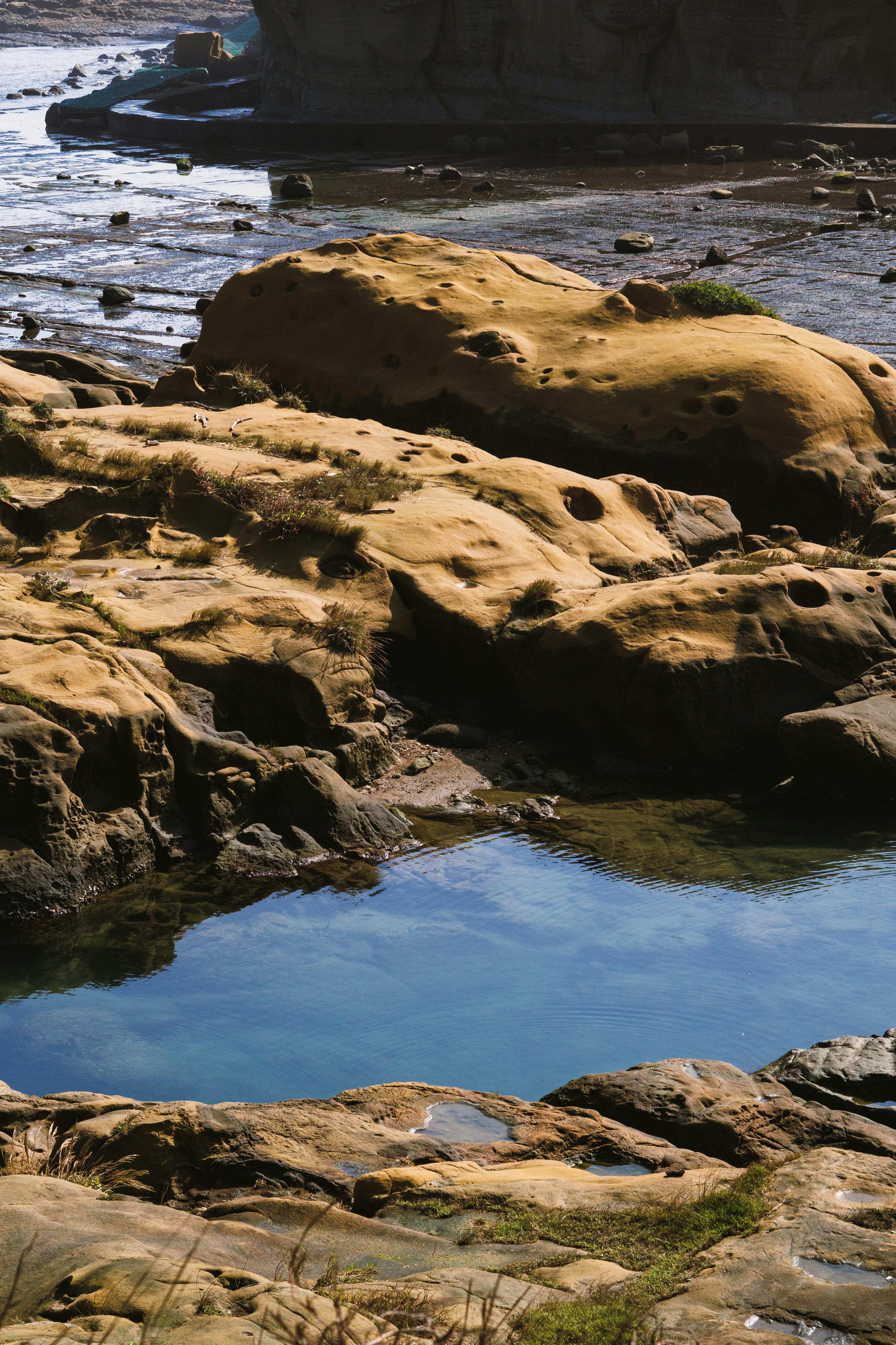 ingyenes Természetes sziklás partvidék dagálymedencékkel és nyugodt kék vízzel egy napsütéses napon. Stockfotó