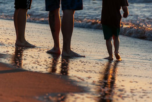 Silhouettes of a family walking along the beach at sunset, enjoying a peaceful moment together.