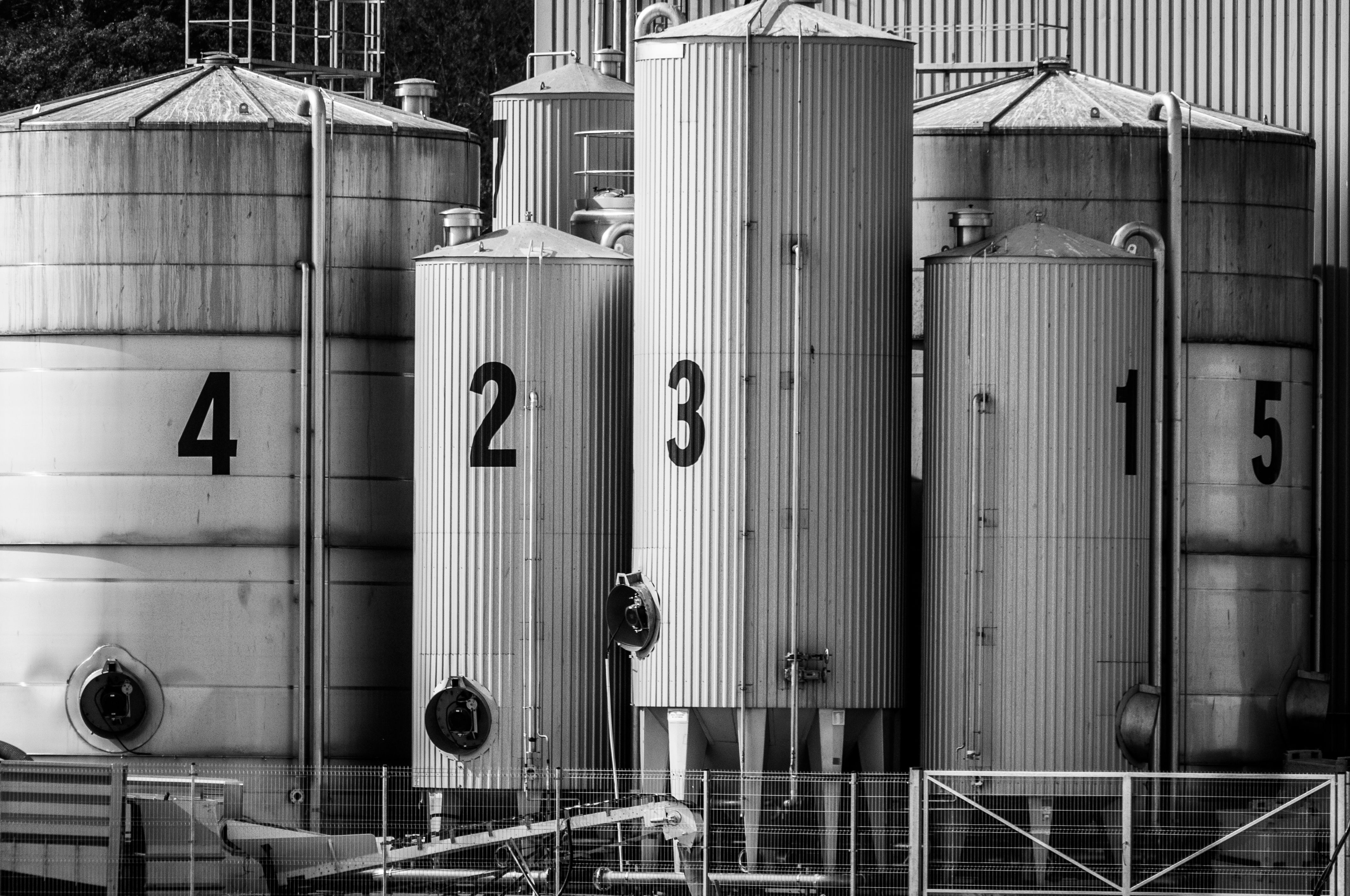 Gratis Sort-hvidt foto af industrielle siloer mærket med store tal fra 1 til 5. Lagerfoto