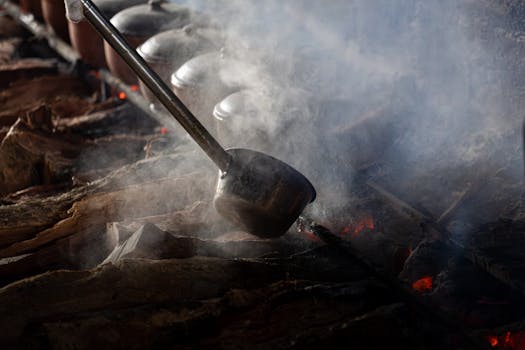 Steaming claypots cooking over an open wood fire in Vietnam, showcasing traditional culinary techniques.