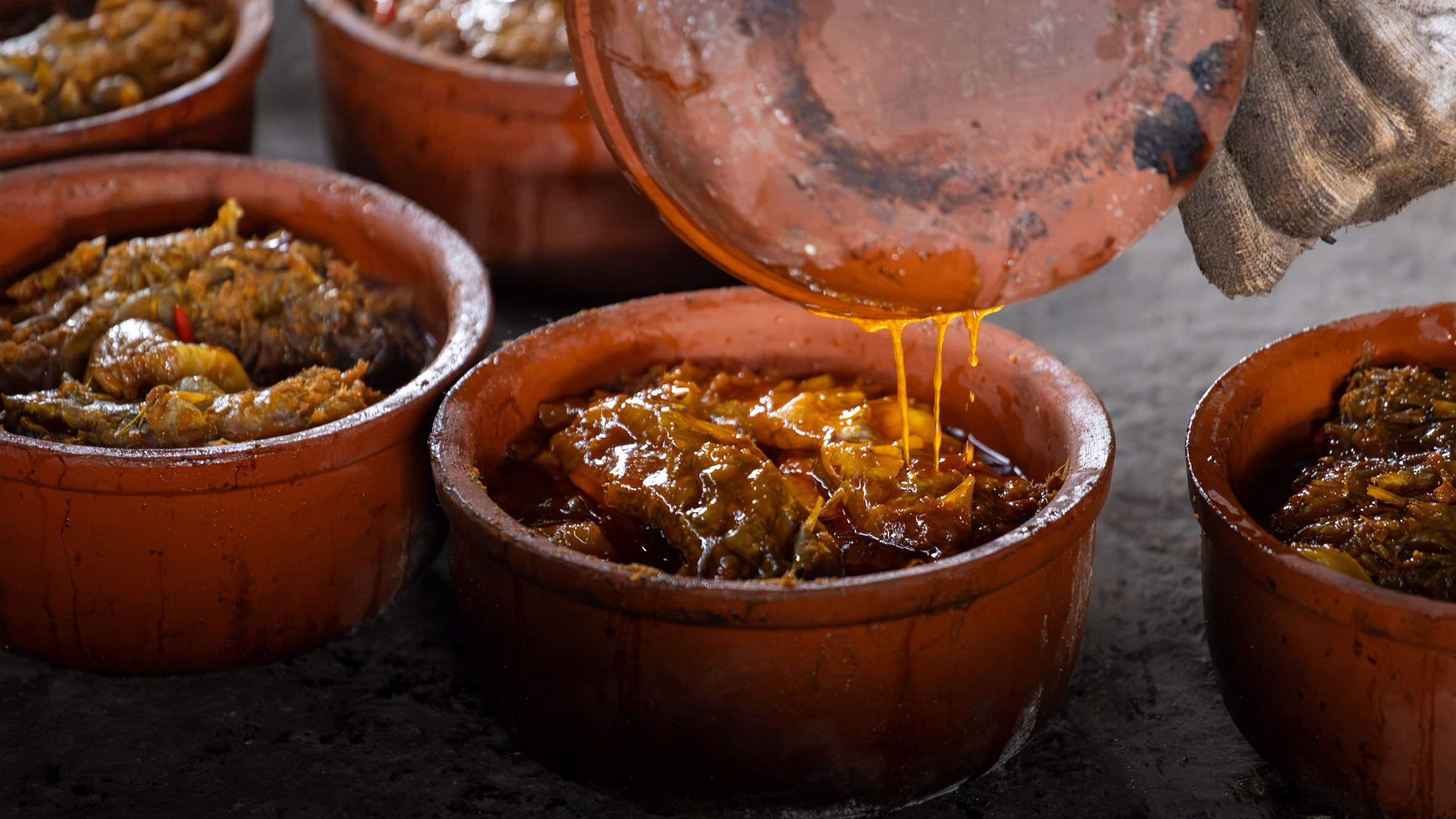 Authentic Vietnamese clay pot fish dish cooking in Nam Định, capturing the richness of Asian cuisine.