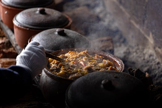 Steaming hot Vietnamese dish cooking in clay pots over rustic stove, adding authentic flavor.