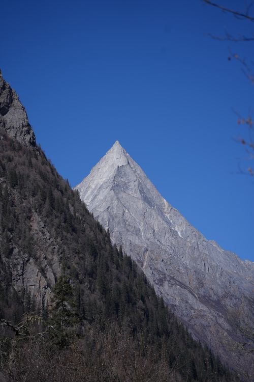 Free A stunning view of a towering mountain peak with a clear blue sky in the background. Stock Photo