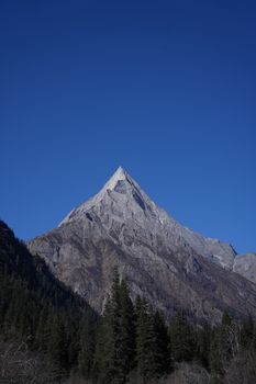 Impressive mountain peak with a deep blue sky backdrop, evoking tranquility and grandeur.