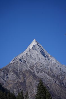 Majestic rocky mountain peak reaching into a clear blue sky, symbolizing strength and serenity.