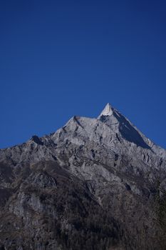 Stunning view of a sharp mountain peak under a bright blue sky, capturing natural beauty and serenity.