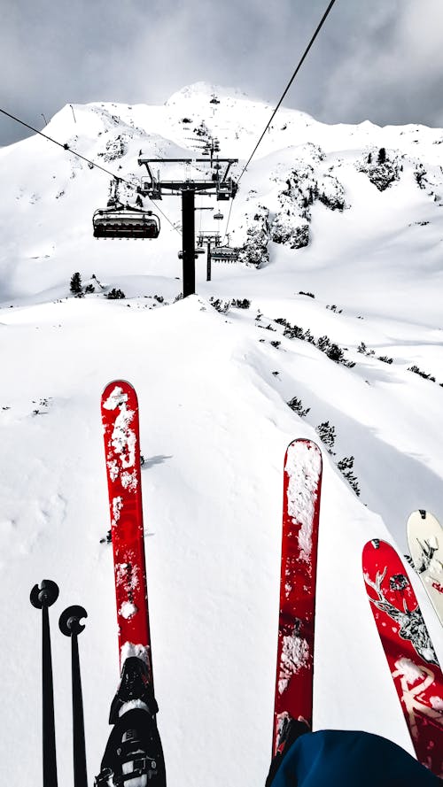 Free Person Riding Ski Lift on Snow Covered Ground Stock Photo
