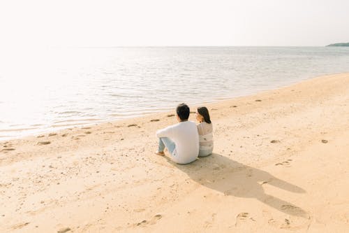 Фото людей, сидящих на берегу моря