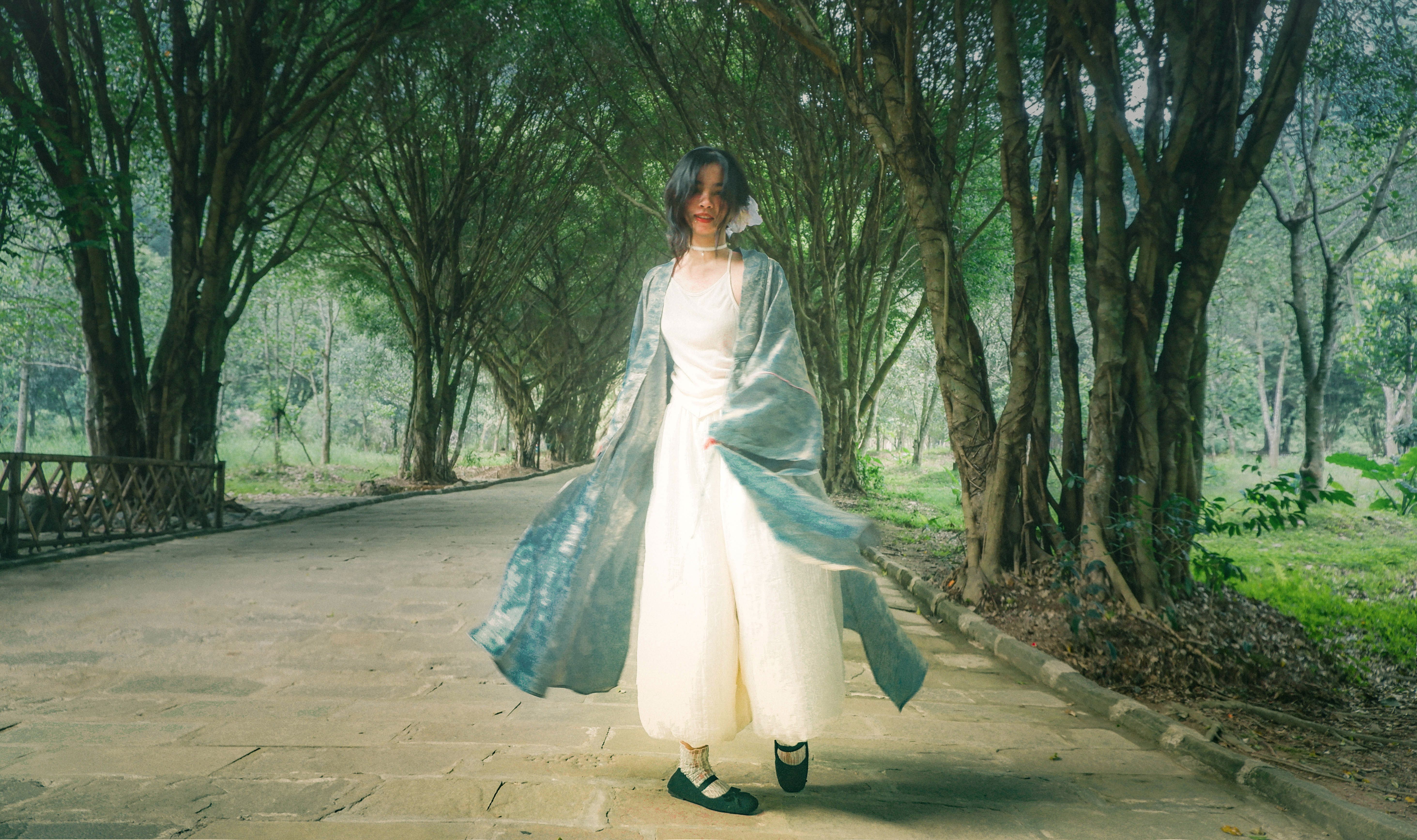 Woman in Light Dress Walking Through Forest Pathway · Free Stock Photo