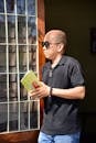 Man Reading by Sunlit Window Holding Book