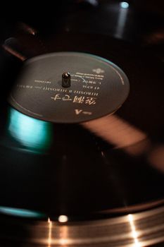 A close-up shot of a vintage vinyl record spinning on a turntable in Tokyo, Japan, capturing analog music culture.