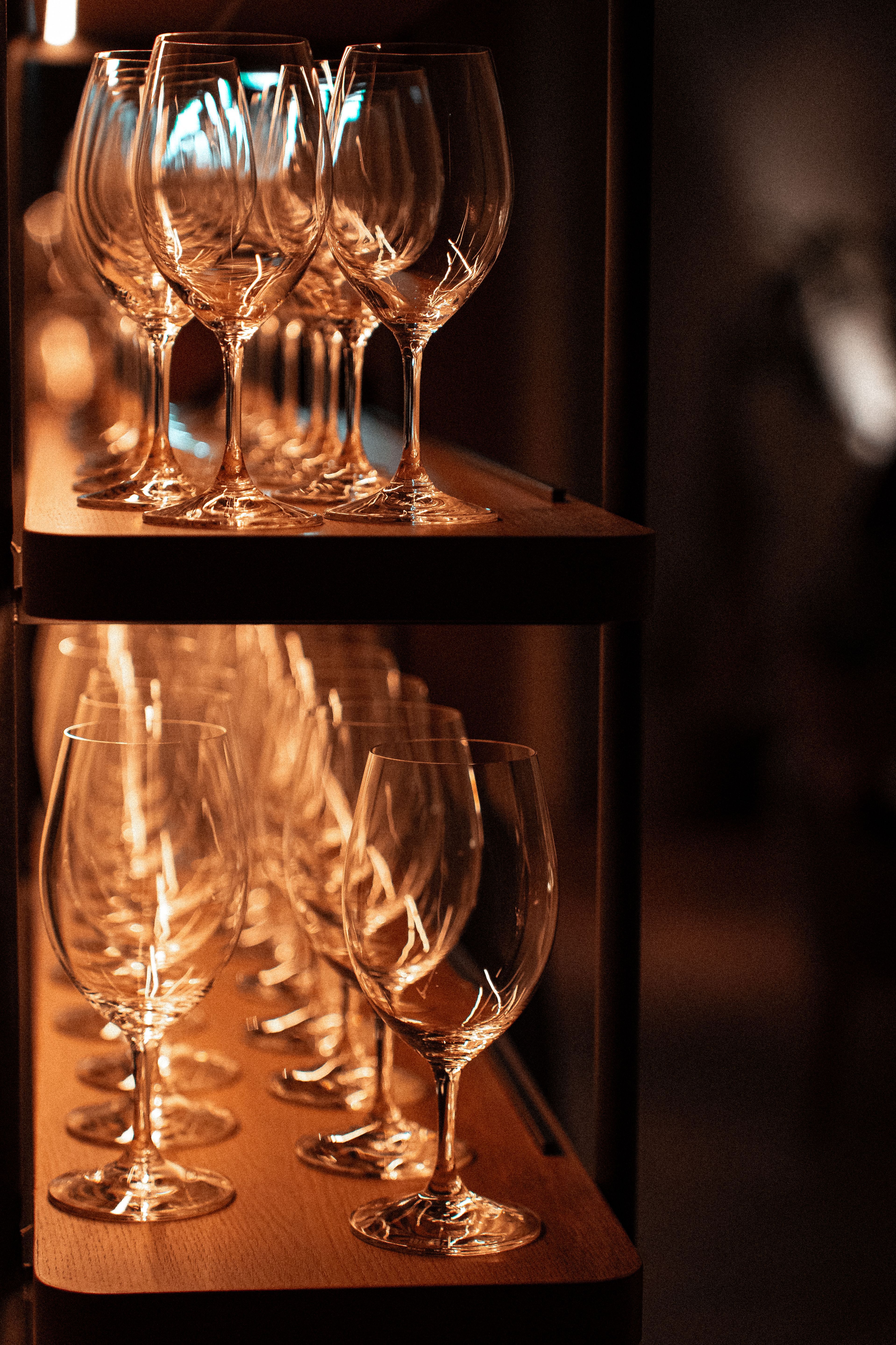 A close-up view of wine glasses neatly arranged on a shelf, creating a warm, elegant ambiance.