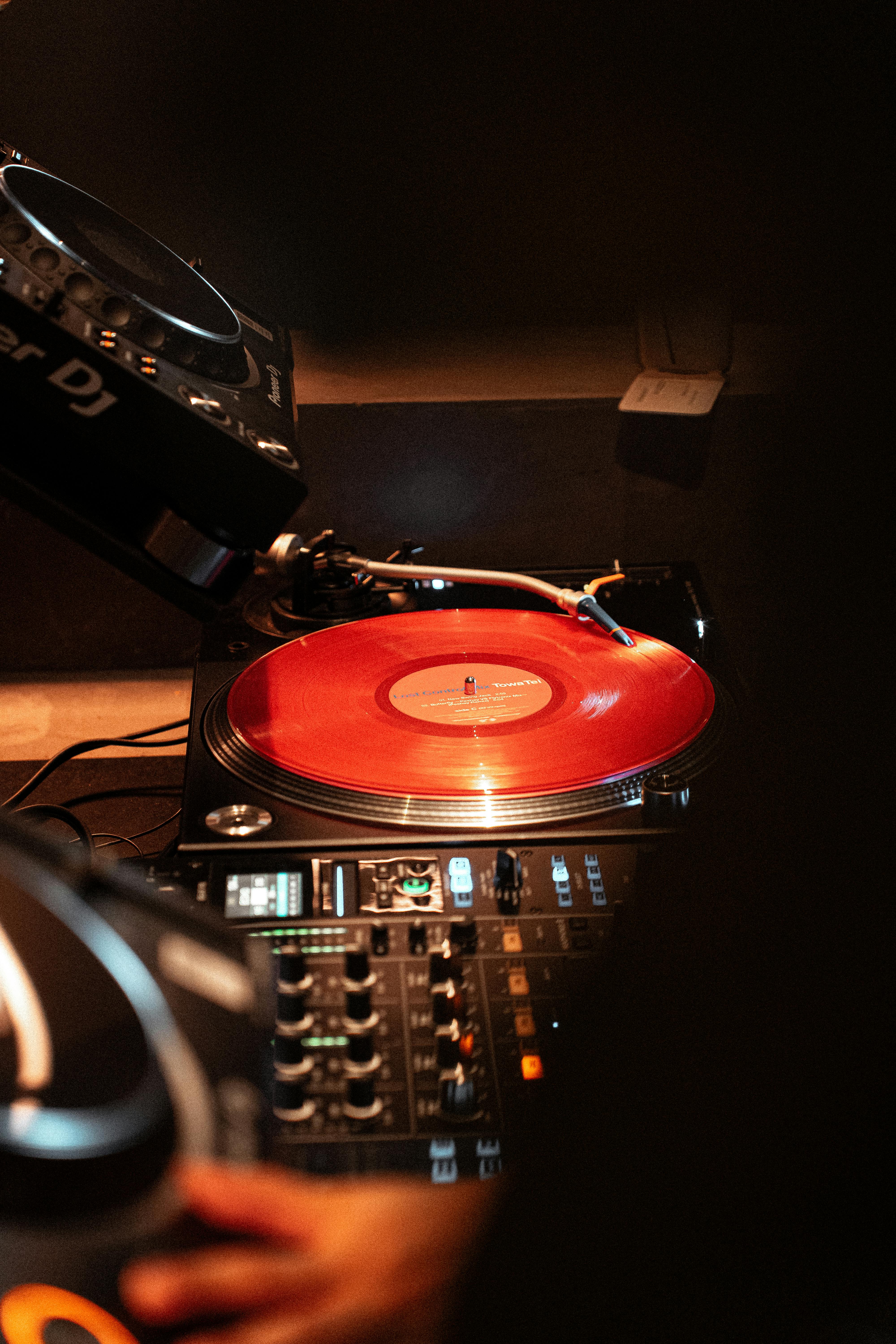 gratis Een dynamische scène van een dj-booth met rode vinylplaten, die de bruisende muziekscene van Tokio 's nachts vastlegt. Stockfoto