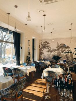 Bright and stylish restaurant interior in sunlight with dining tables and decor.