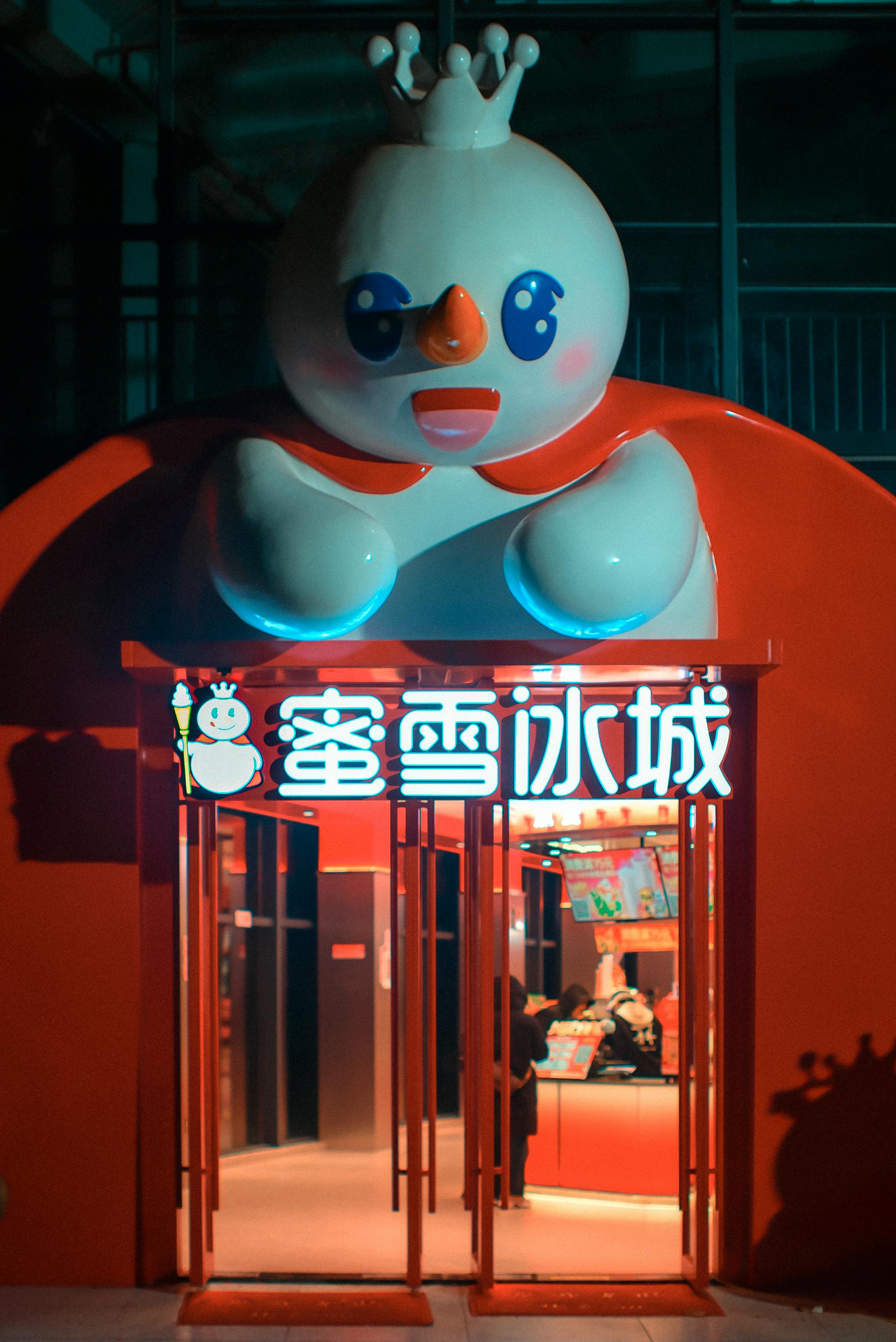 Kostenlos Charmante rote Eisdielen-Eingangstür mit Schneemann-Maskottchen bei Nacht. Stock-Foto