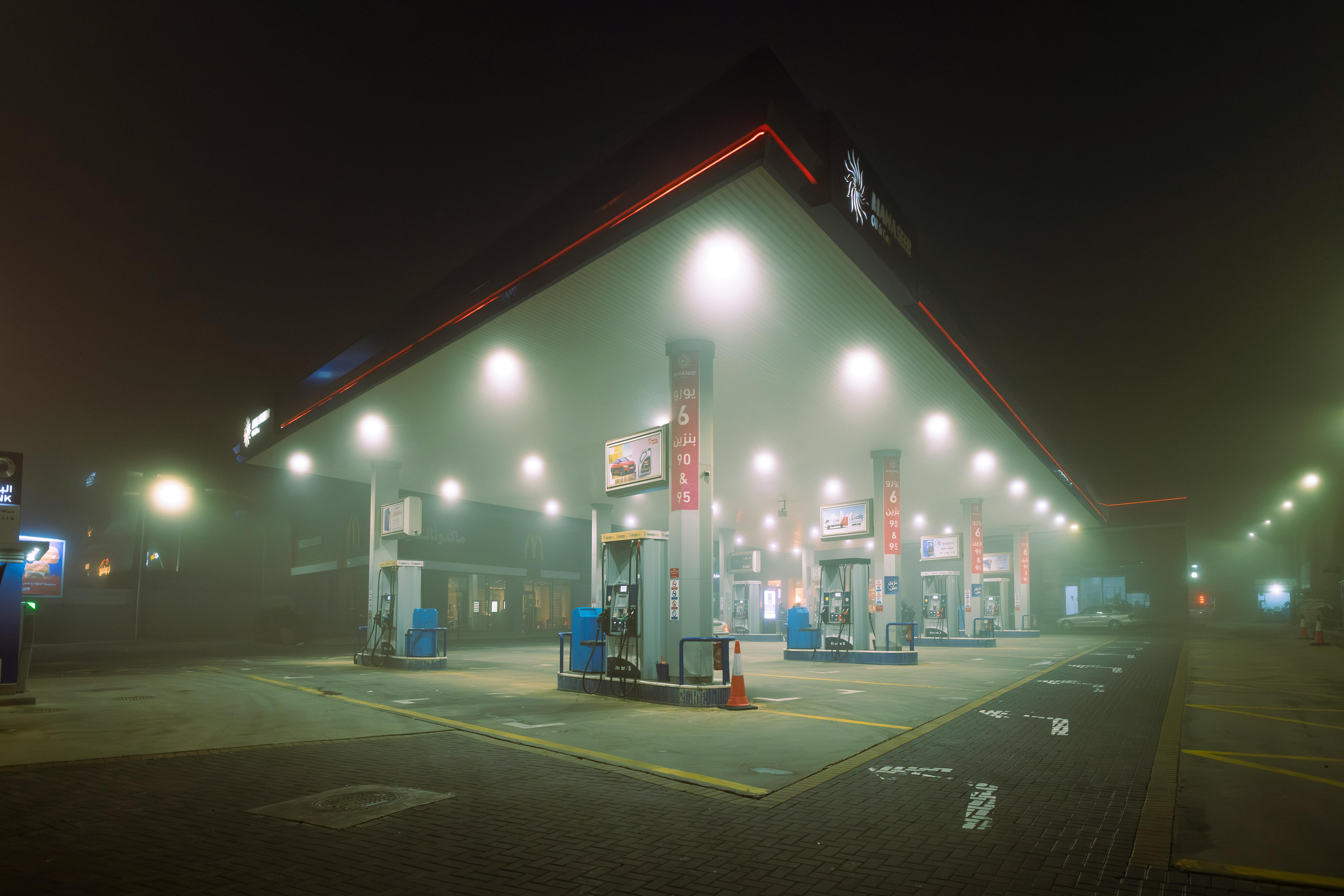 Gratis En tåget nattescene ved en oplyst tankstation i Jordan, der fremviser en mystisk og stille atmosfære. Lagerfoto