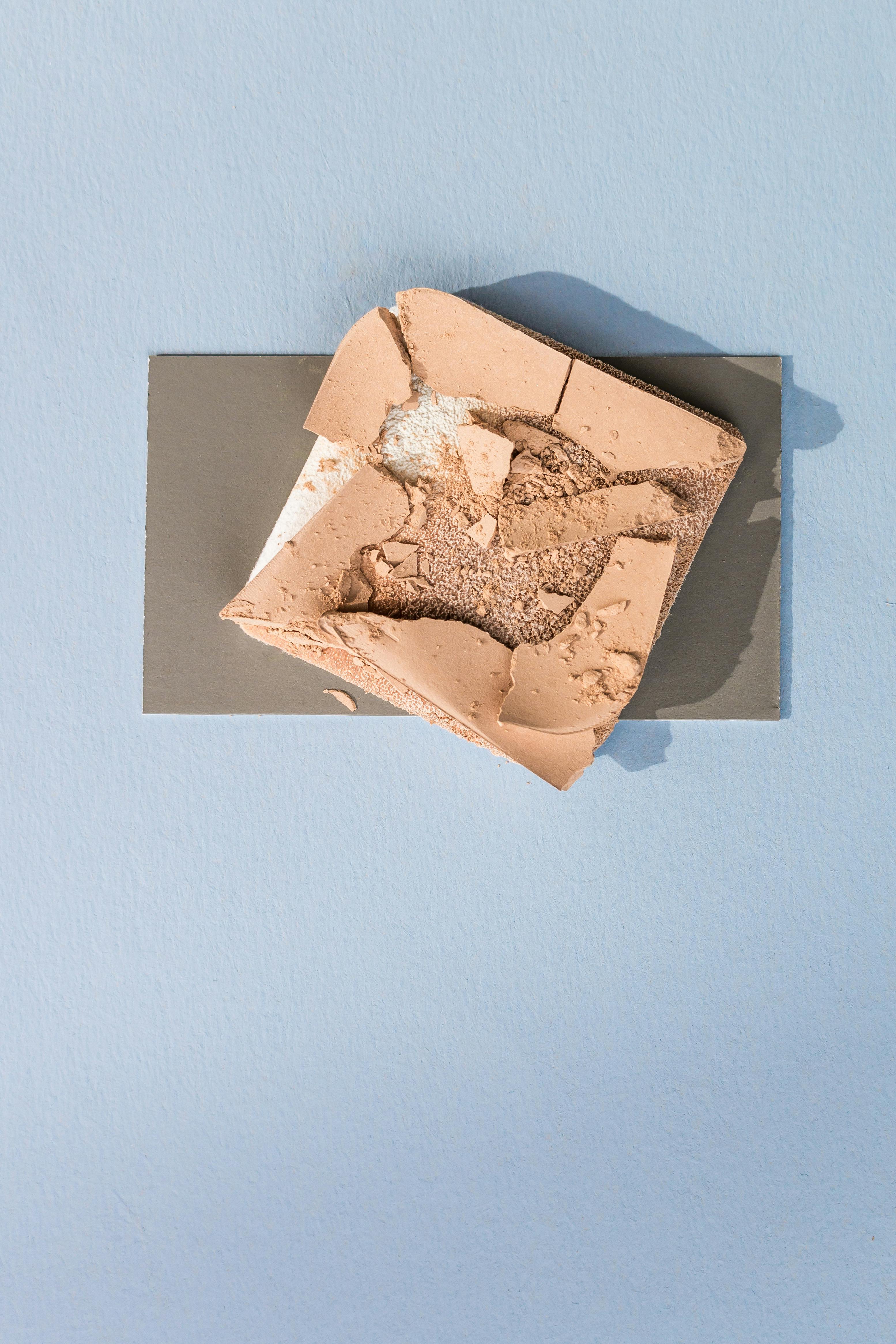 Miễn phí Ảnh chụp từ trên cao cho thấy hộp phấn phủ bị vỡ nằm trên bề mặt màu xanh có vân. Ảnh lưu trữ