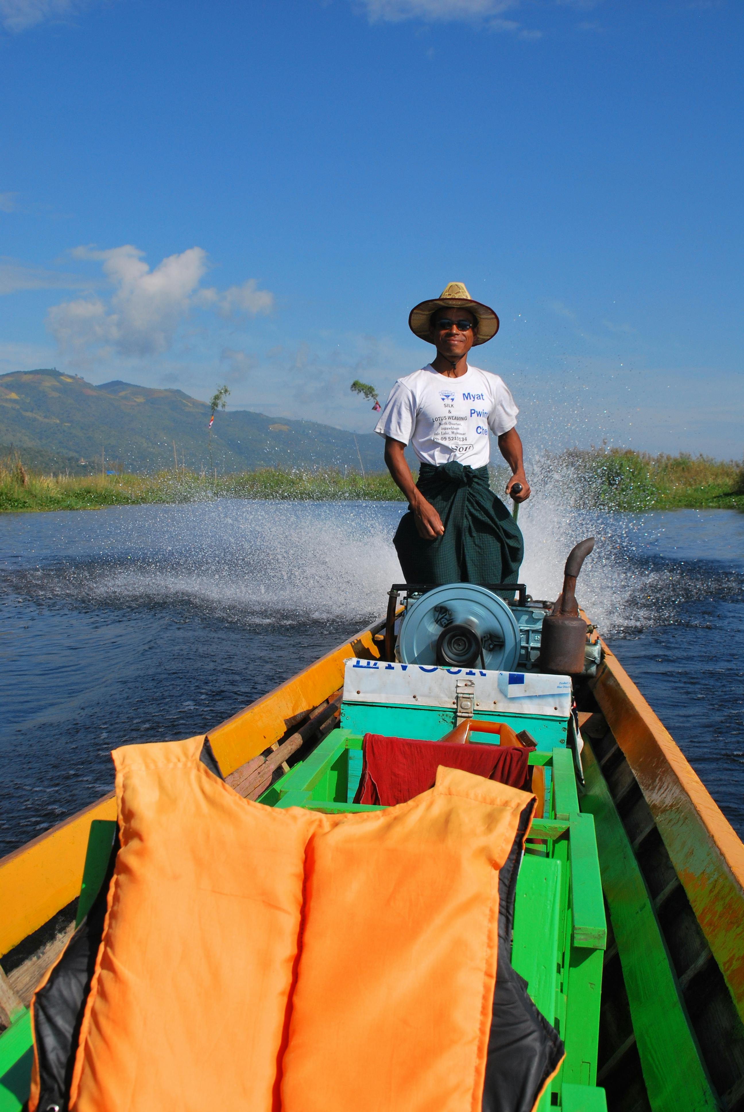 Miễn phí Một người đàn ông khéo léo điều khiển chiếc thuyền máy trên mặt hồ tĩnh lặng dưới bầu trời xanh trong vắt. Ảnh lưu trữ