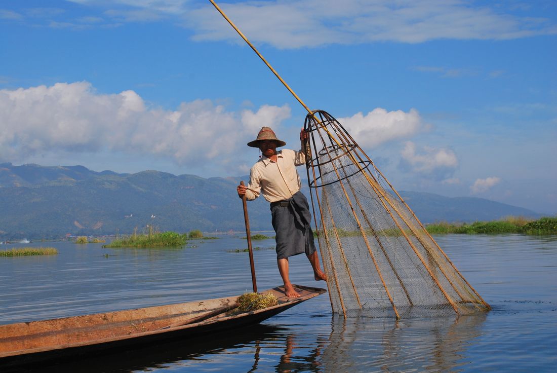 Intha fisherman casting a conical net on Inle Lake, Myanmar