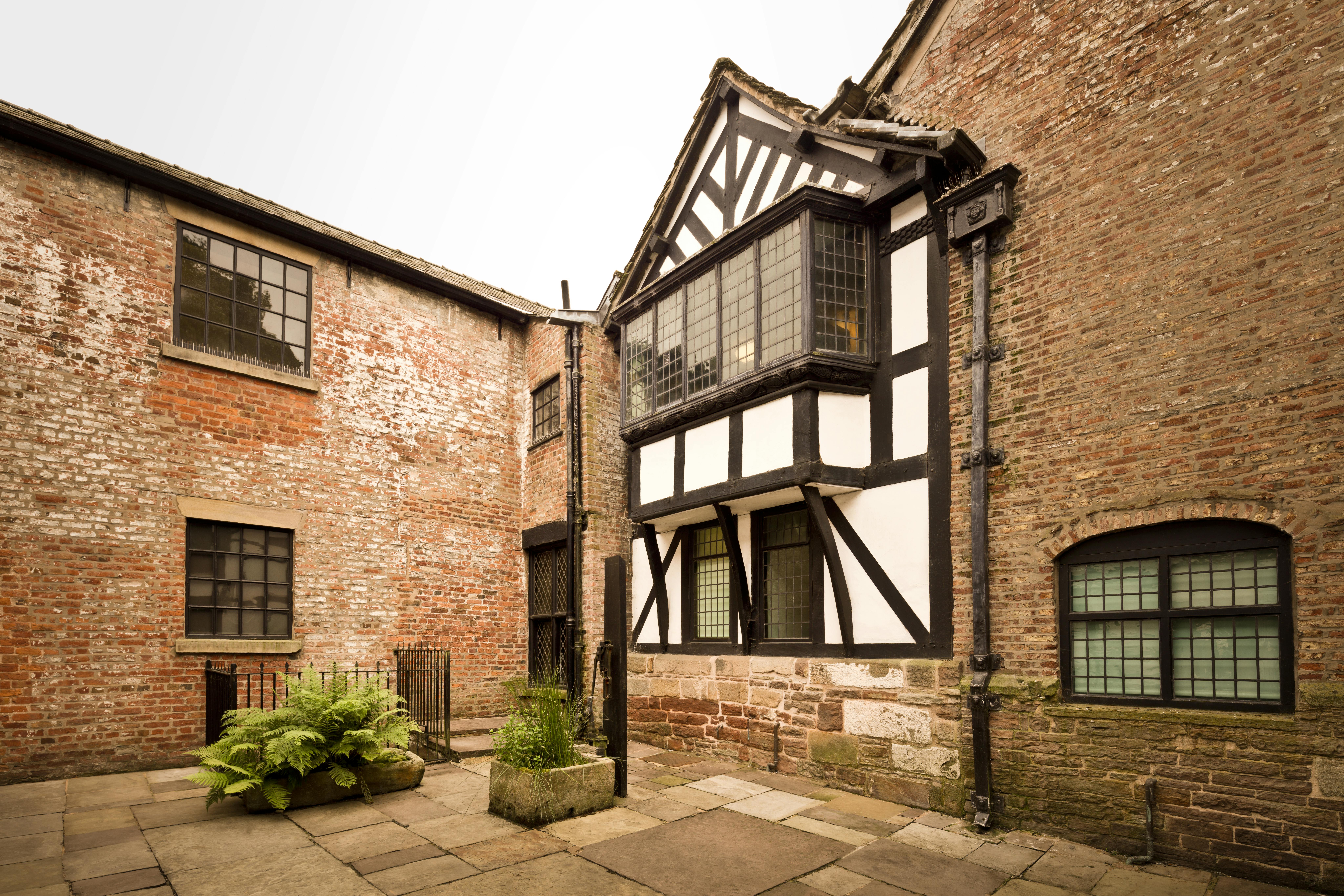 Explore the heritage-rich courtyard of Astley Hall, showcasing classic English timber-frame architecture.