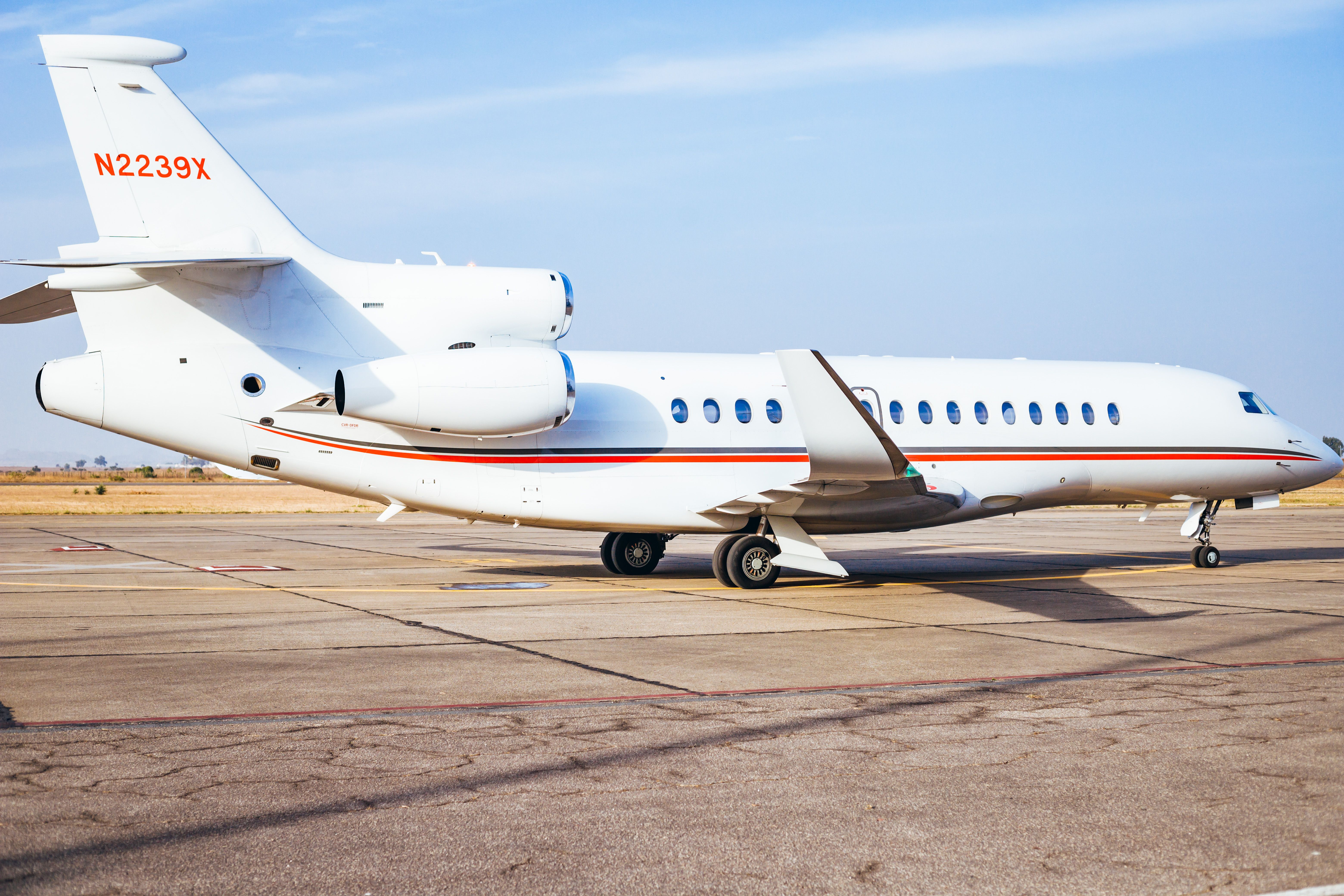 A sleek private jet parked on the runway under a clear sky in Jos, Nigeria.