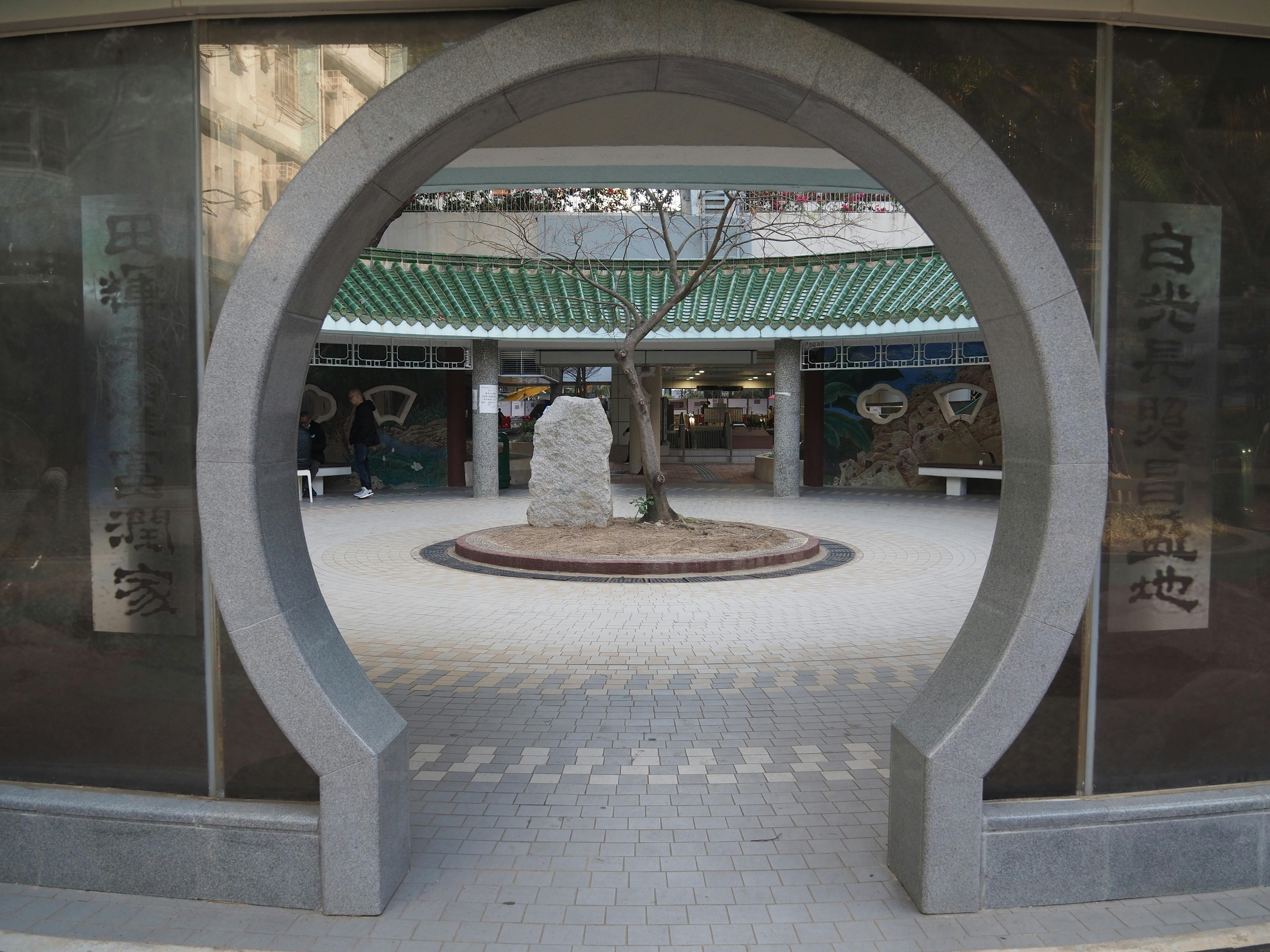 gratis Uitzicht door een traditionele maanpoort in Hongkong, die toegang geeft tot een binnenplaats met kenmerkende Aziatische architectuur. Stockfoto