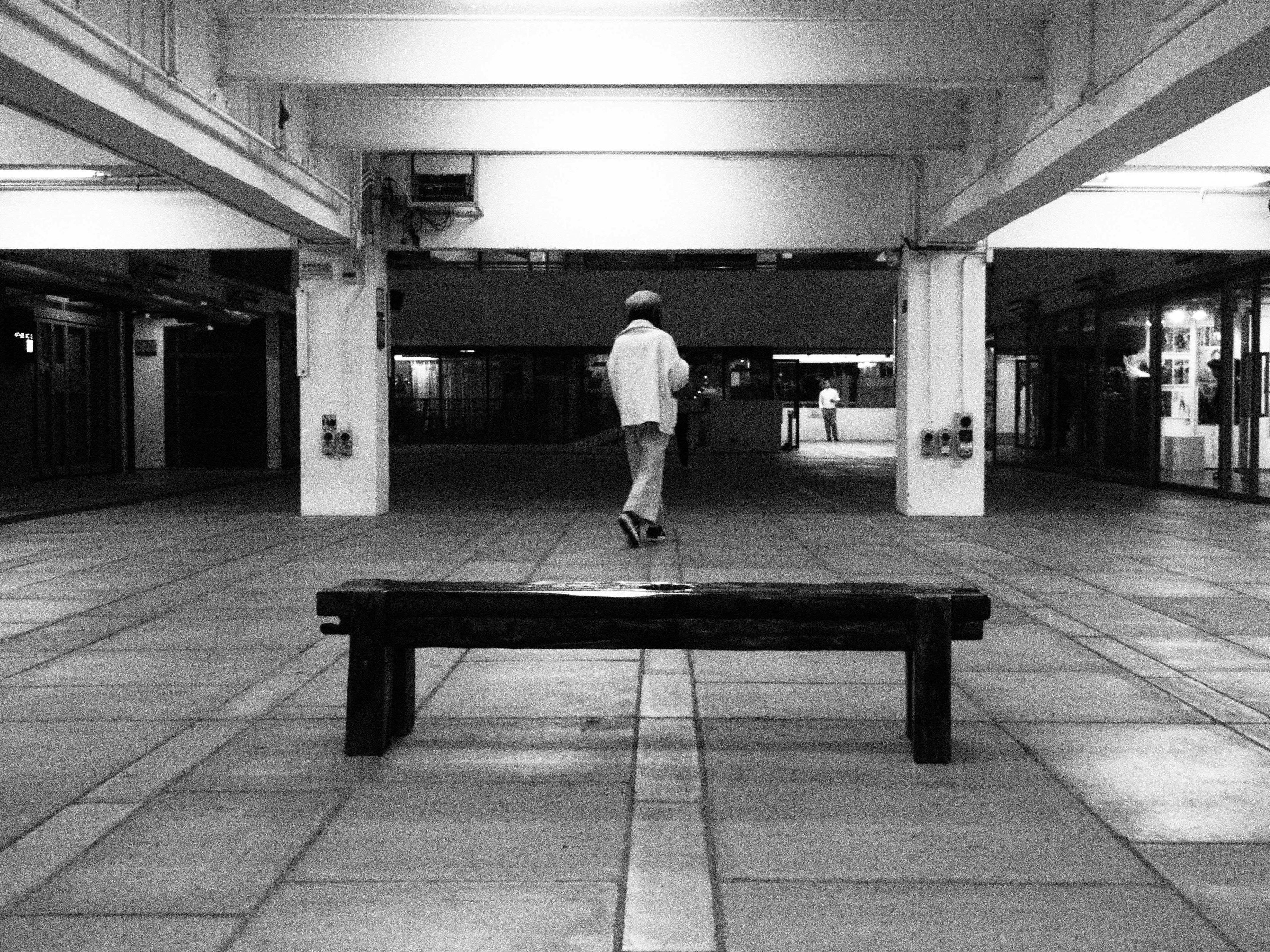 Gratis Elegante fotografía en blanco y negro de una figura solitaria caminando en un interior de Hong Kong. Foto de stock