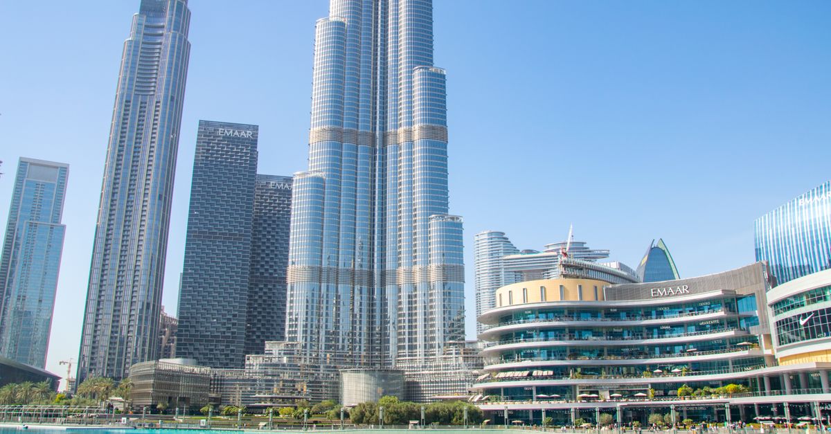 Stunning view of Burj Khalifa and surrounding skyscrapers reflecting in a tranquil pool, Dubai.