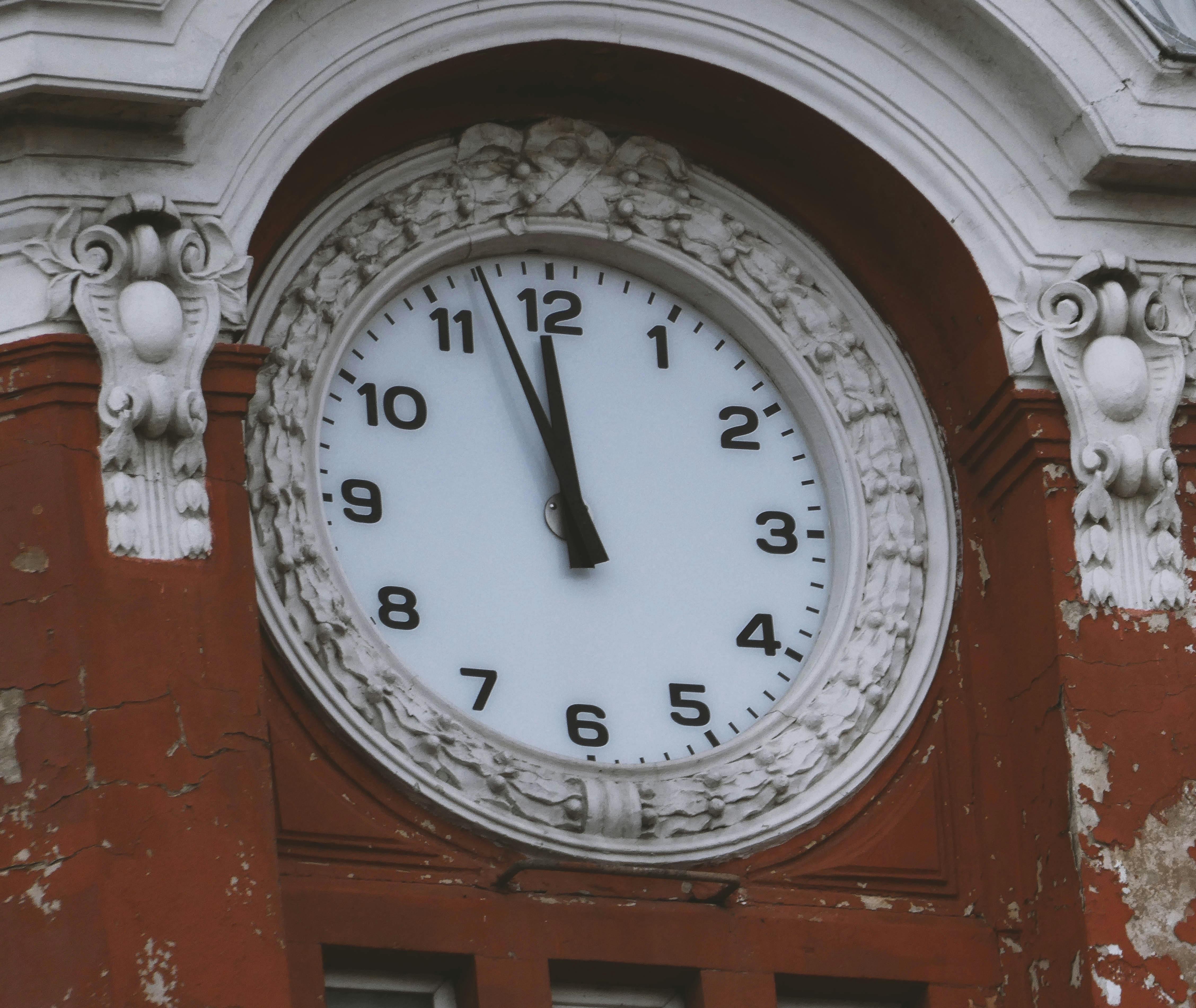 Ücretsiz Gece yarısını veya öğle vaktini gösteren, zamansız mimariyi yansıtan süslü bir saat kulesinin yakın çekim görüntüsü. Stok Fotoğraflar