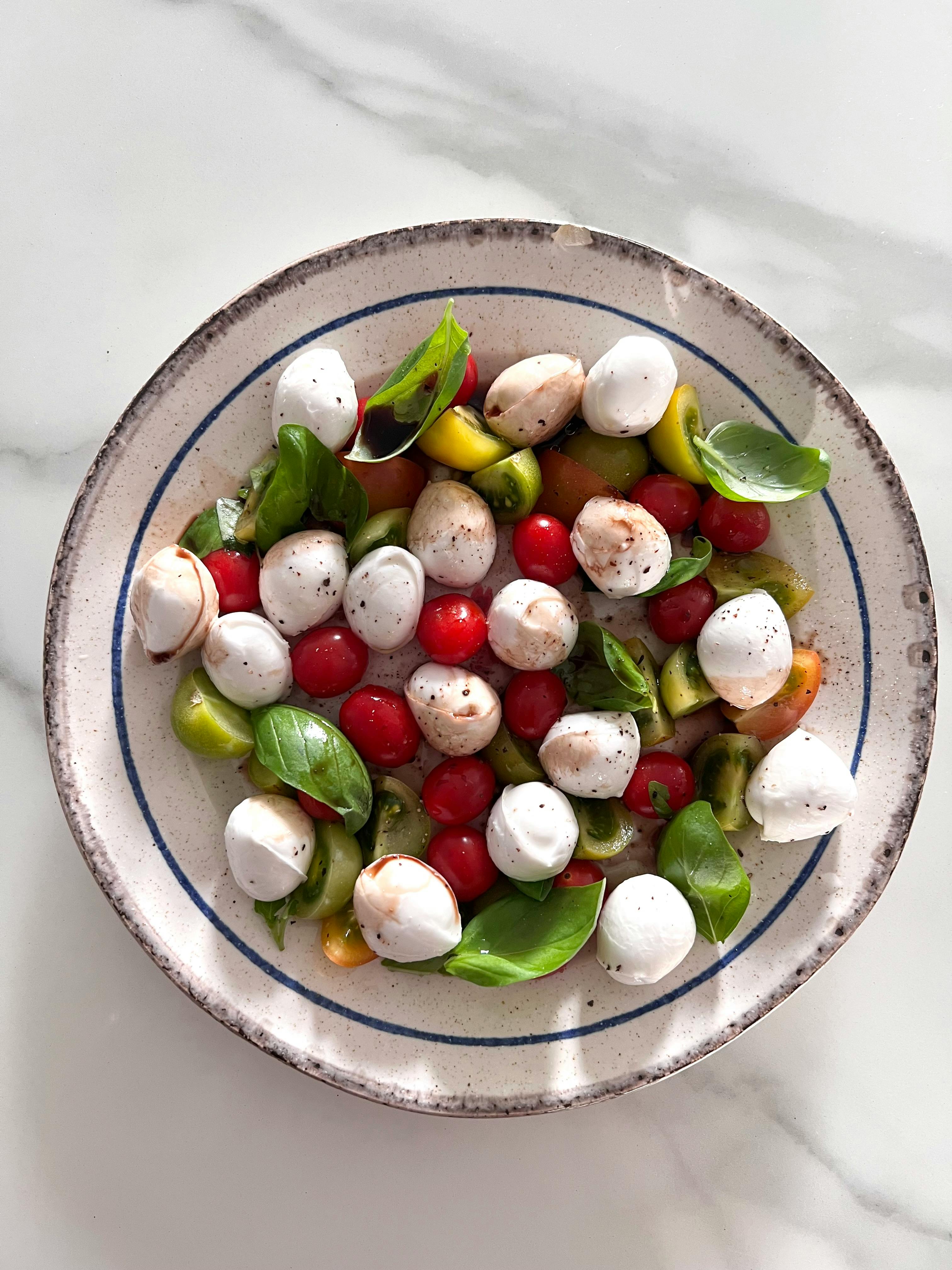 Miễn phí Salad Caprese tươi ngon với cà chua bi và phô mai mozzarella trên đĩa sứ. Ảnh lưu trữ