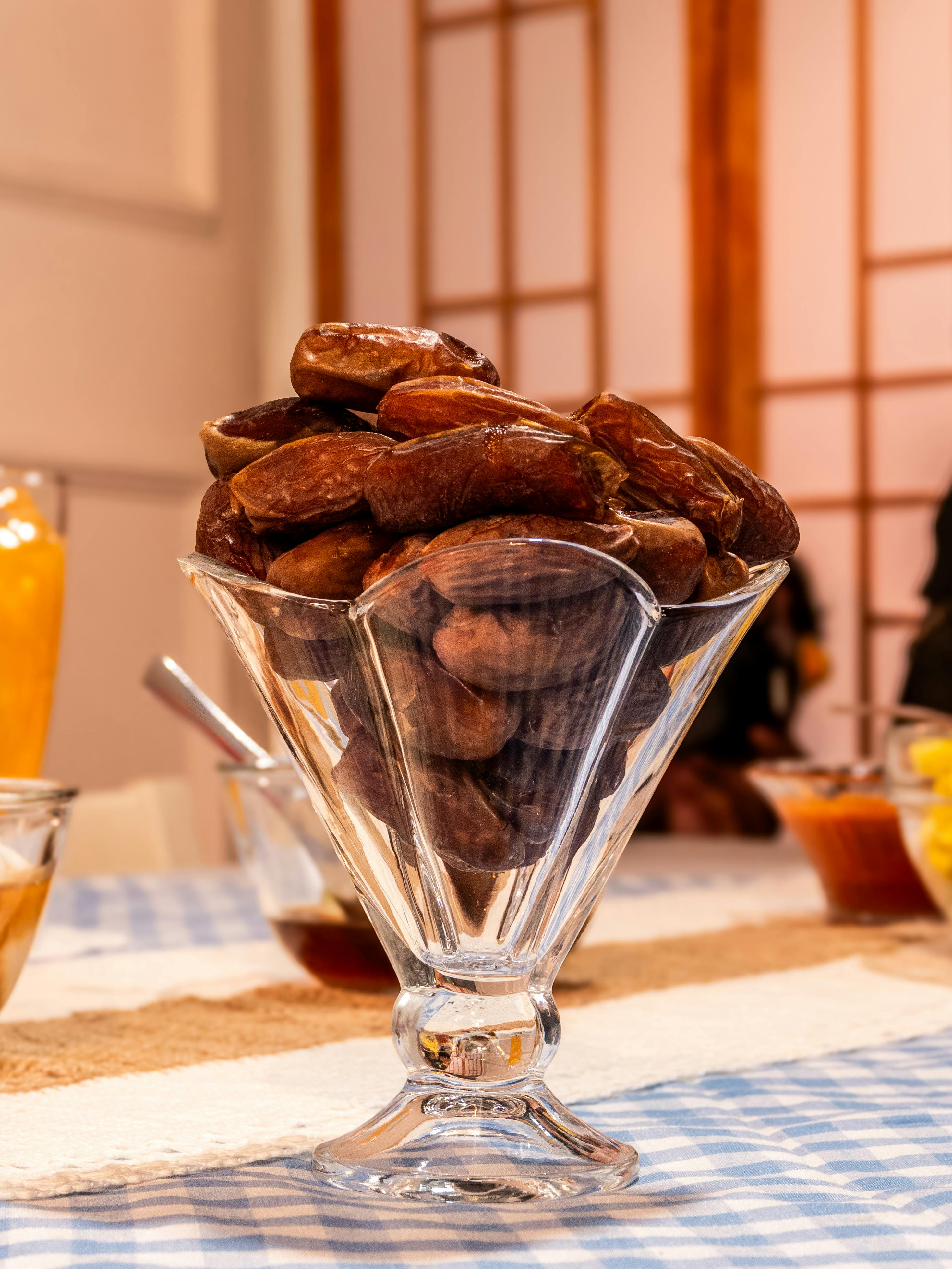 Miễn phí Một chiếc bát thủy tinh trong suốt đựng đầy những quả chà là ngon lành được bày trên bàn ăn trong nhà. Ảnh lưu trữ