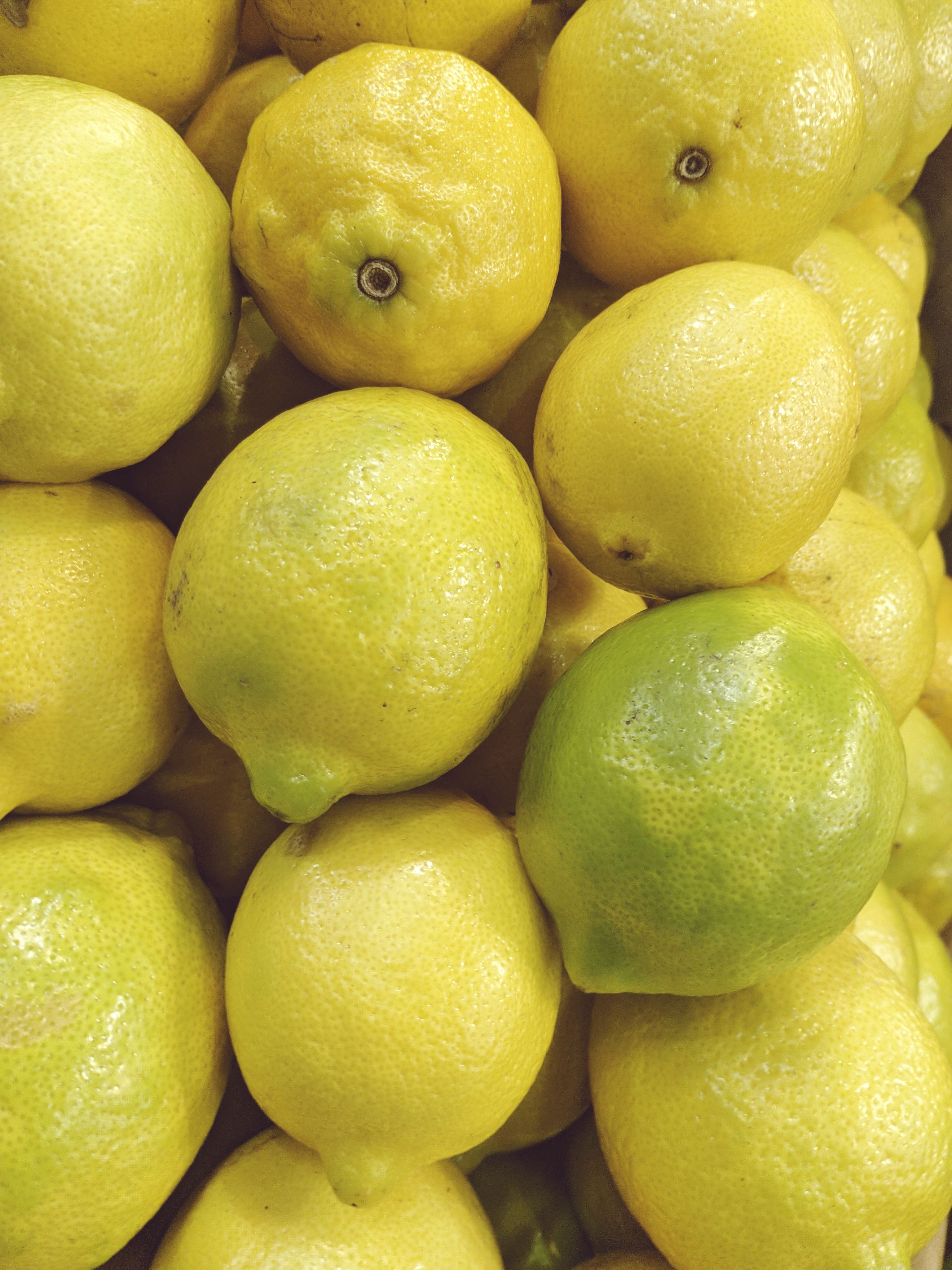 Close-up of fresh yellow lemons piled in a grocery store, showcasing vibrant colors.