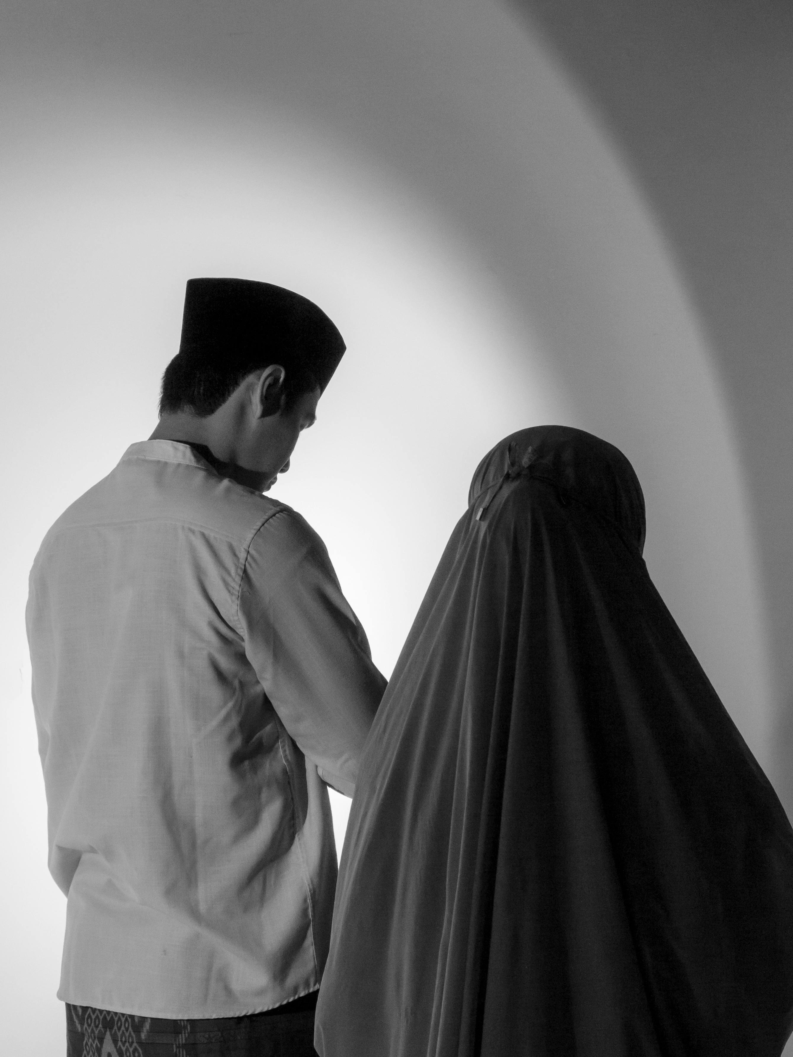 Ücretsiz Sanatsal bir üslupla çekilmiş, yan yana duran bir erkek ve bir kadını gösteren siyah beyaz bir fotoğraf. Stok Fotoğraflar