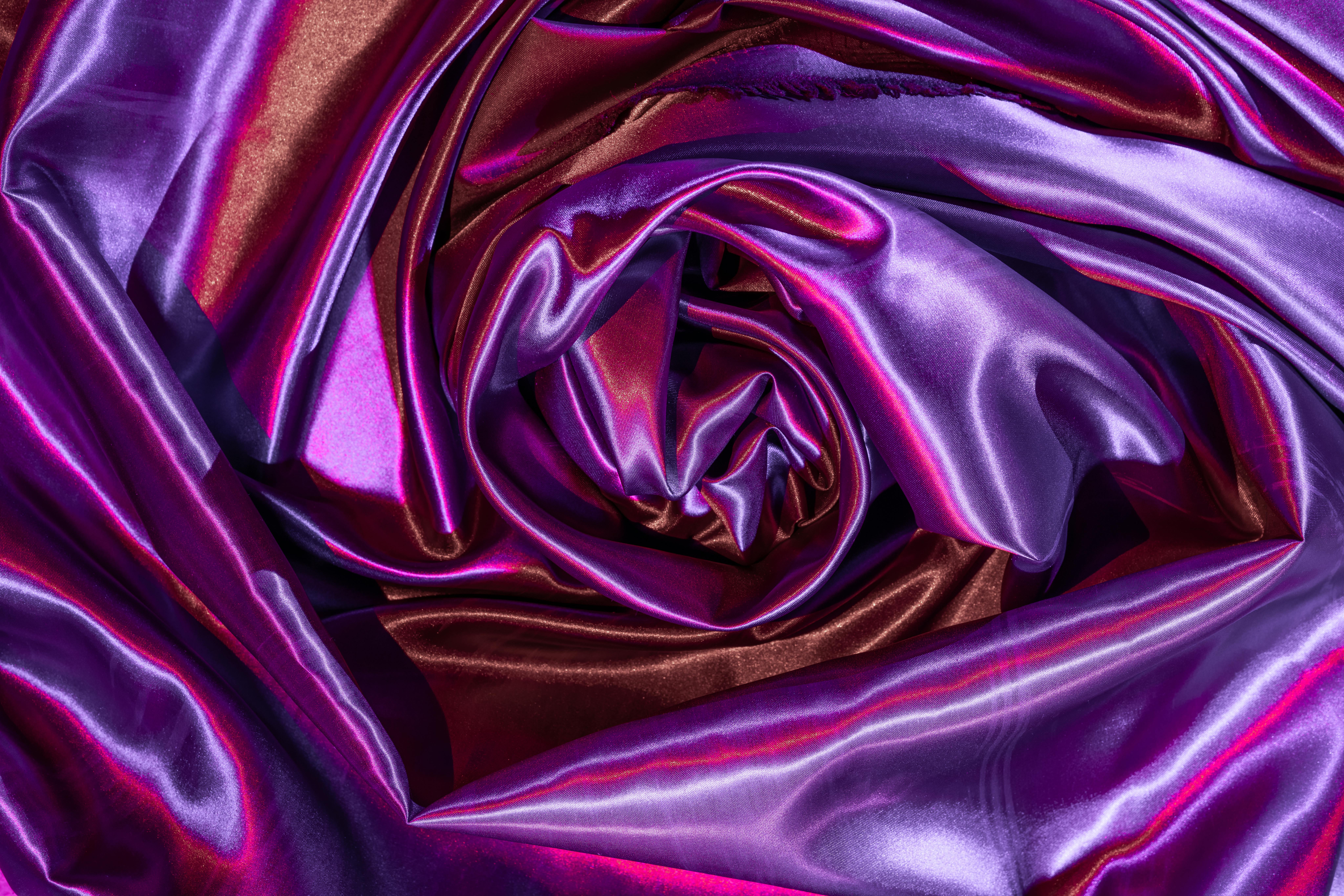 Gratuit Imagine artistică abstractă a unei țesături satinate în vârtejuri cu nuanțe vibrante de violet și roșu, care evidențiază textura și strălucirea. Fotografie de stoc