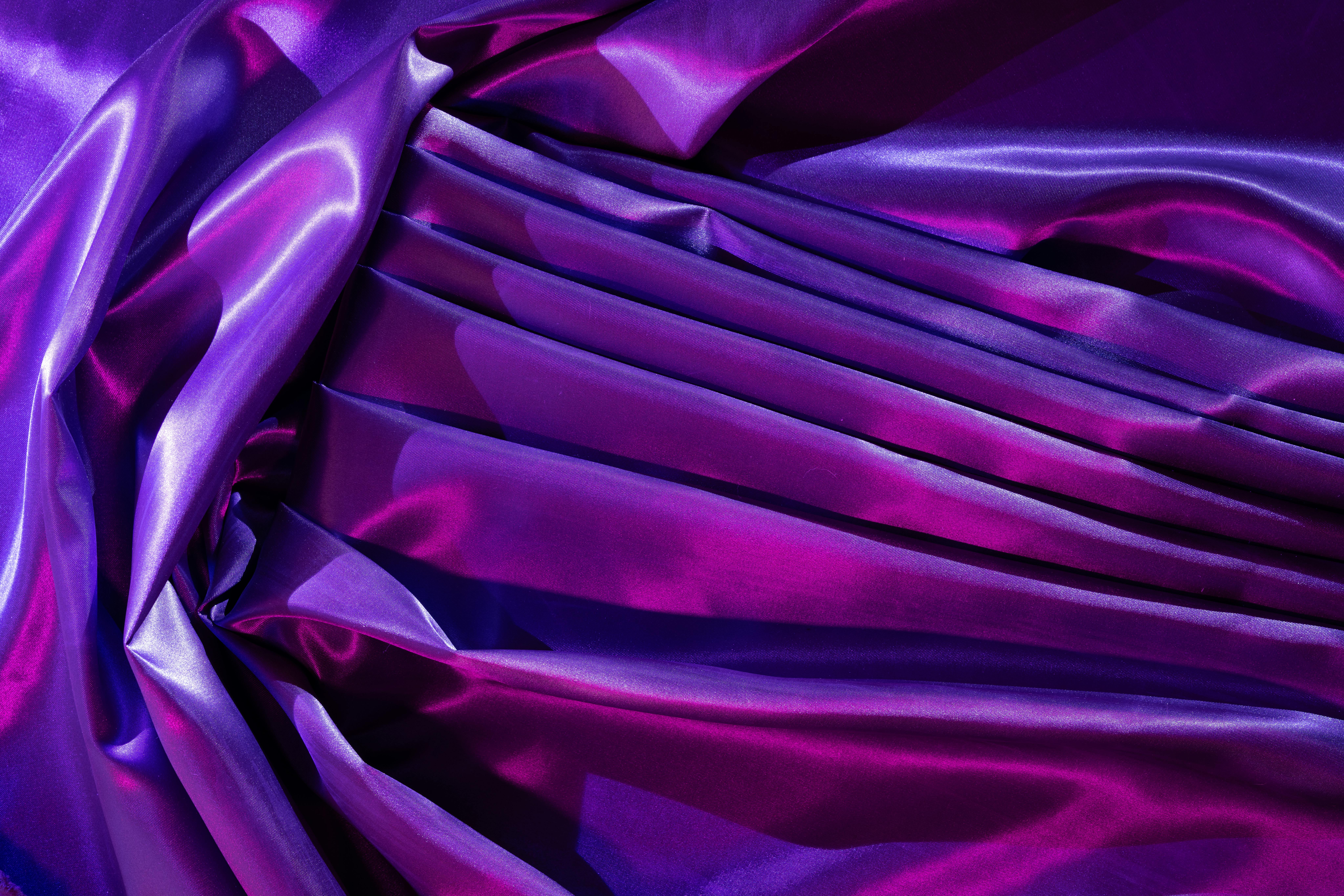 Free Luxurious purple satin fabric displaying elegant folds and vibrant color contrast, ideal for creative backgrounds. Stock Photo