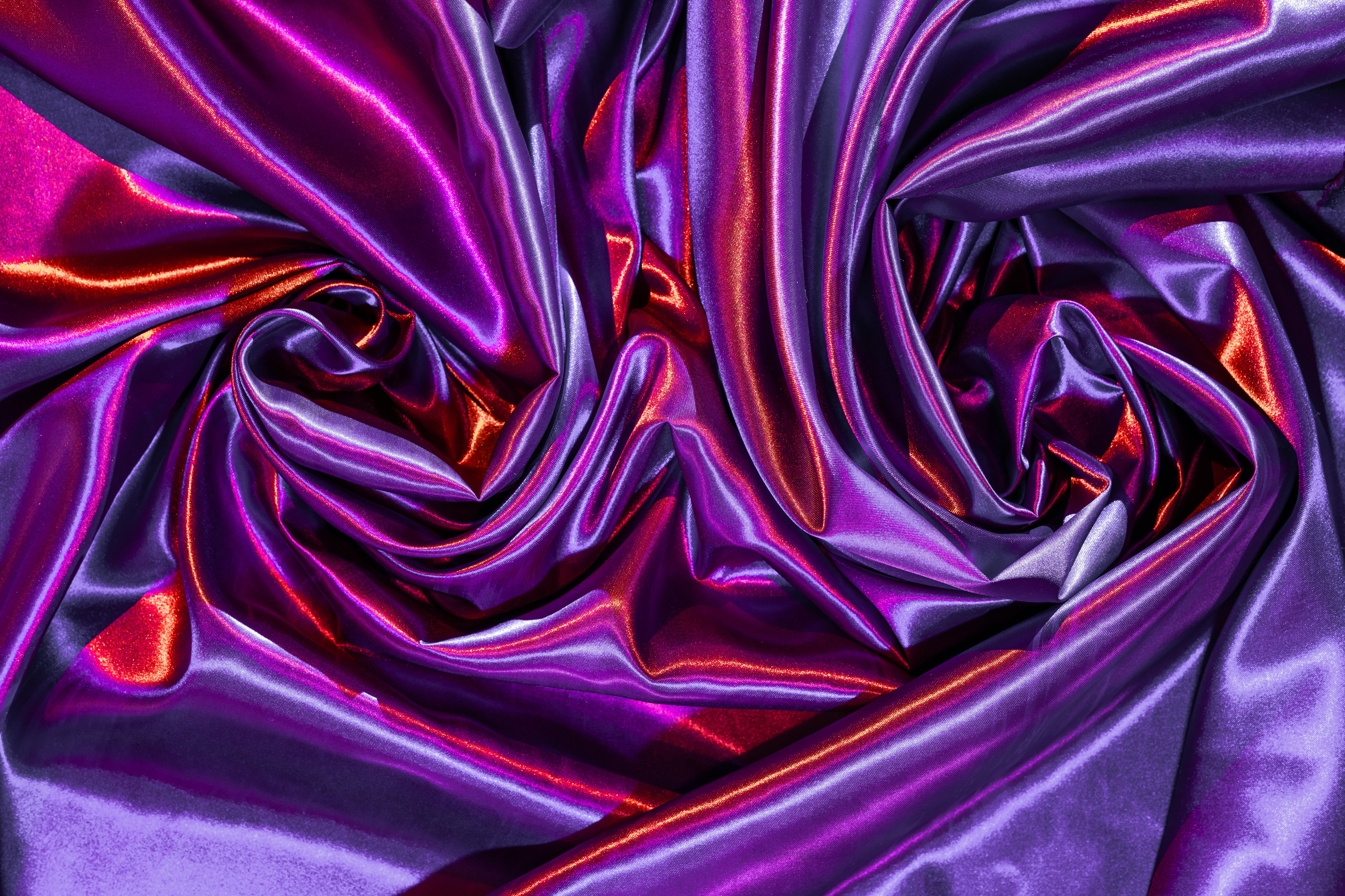 Ilmainen Hohtavan violetin ja punaisen silkkikankaan laskokset luovat eloisan abstraktin kuvion, jolla on ylellinen tunnelma. Kuvapankkikuva