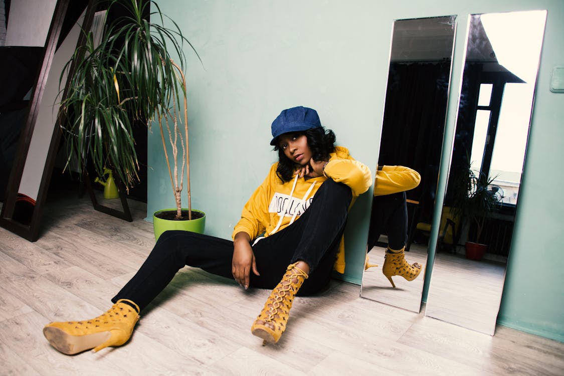 Free Woman in Yellow Jacket and Black Pants Sitting on the Floor Stock Photo