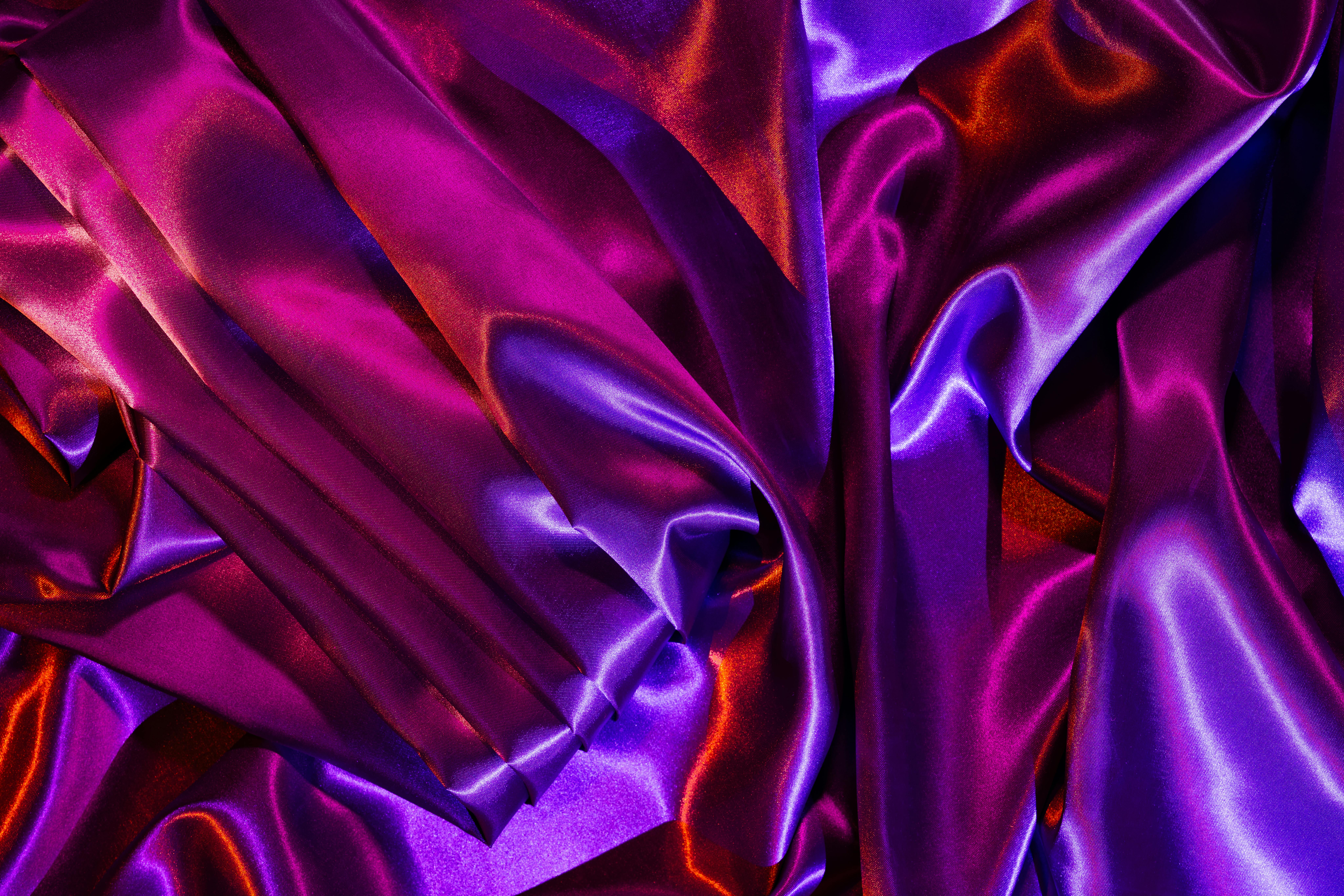 gratis Close-up van een levendige paarse en roze satijnen stof met ingewikkelde plooien, die een luxueuze textuur laat zien. Stockfoto